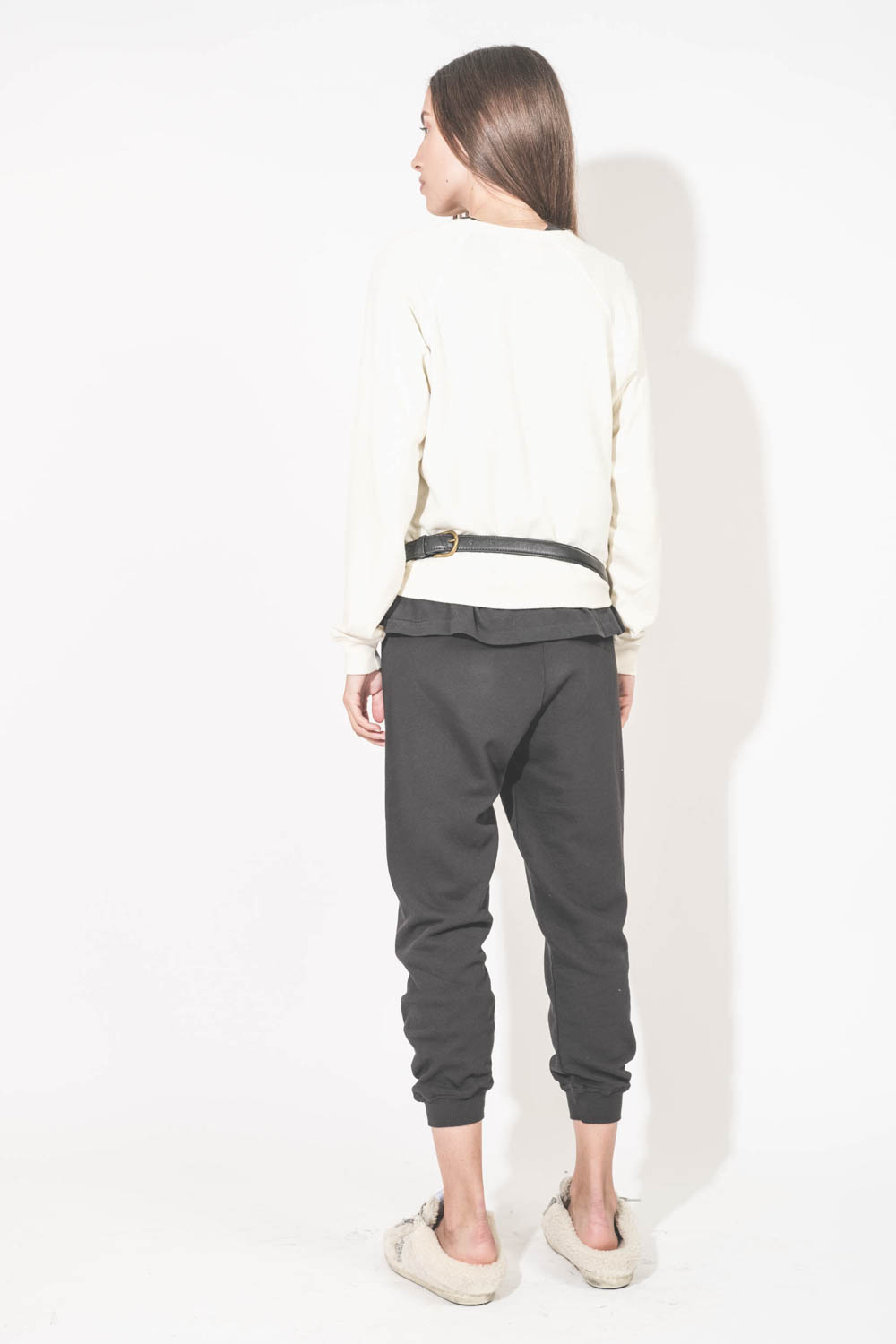 Sac banane en cuir chèvre grainé noir Lino Jérôme Dreyfuss. Porté de dos avec un sweat-shirt écru Shrunken The Great et un pantalon de jogging court noir The Great. Sneakers Super Star sabot en Shearling écru Golden Goose.