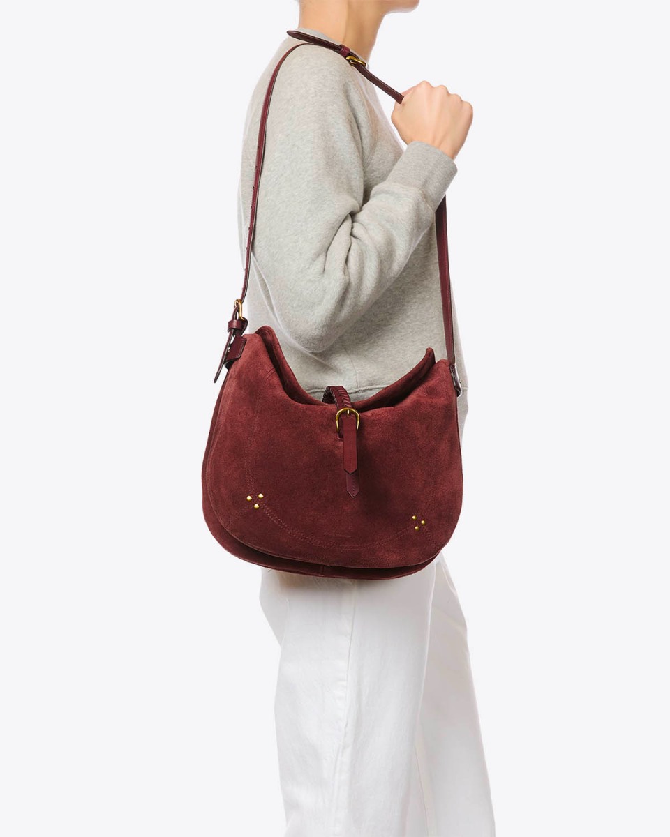 Sac besace Luis J&eacute;r&ocirc;me Dreyfuss en cuir su&eacute;d&eacute; brul&eacute;, port&eacute; de profil &agrave; l'&eacute;paule bandouli&egrave;re longue.