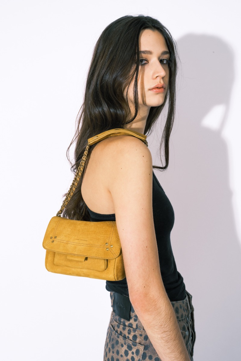 Sac Lulu S Jérôme Dreyfuss en cuir de taurillon imprimé croco moutarde, porté court à l'épaule avec un débardeur noir Isabel Marant Étoile et une mini-jupe léopard Mikuta.