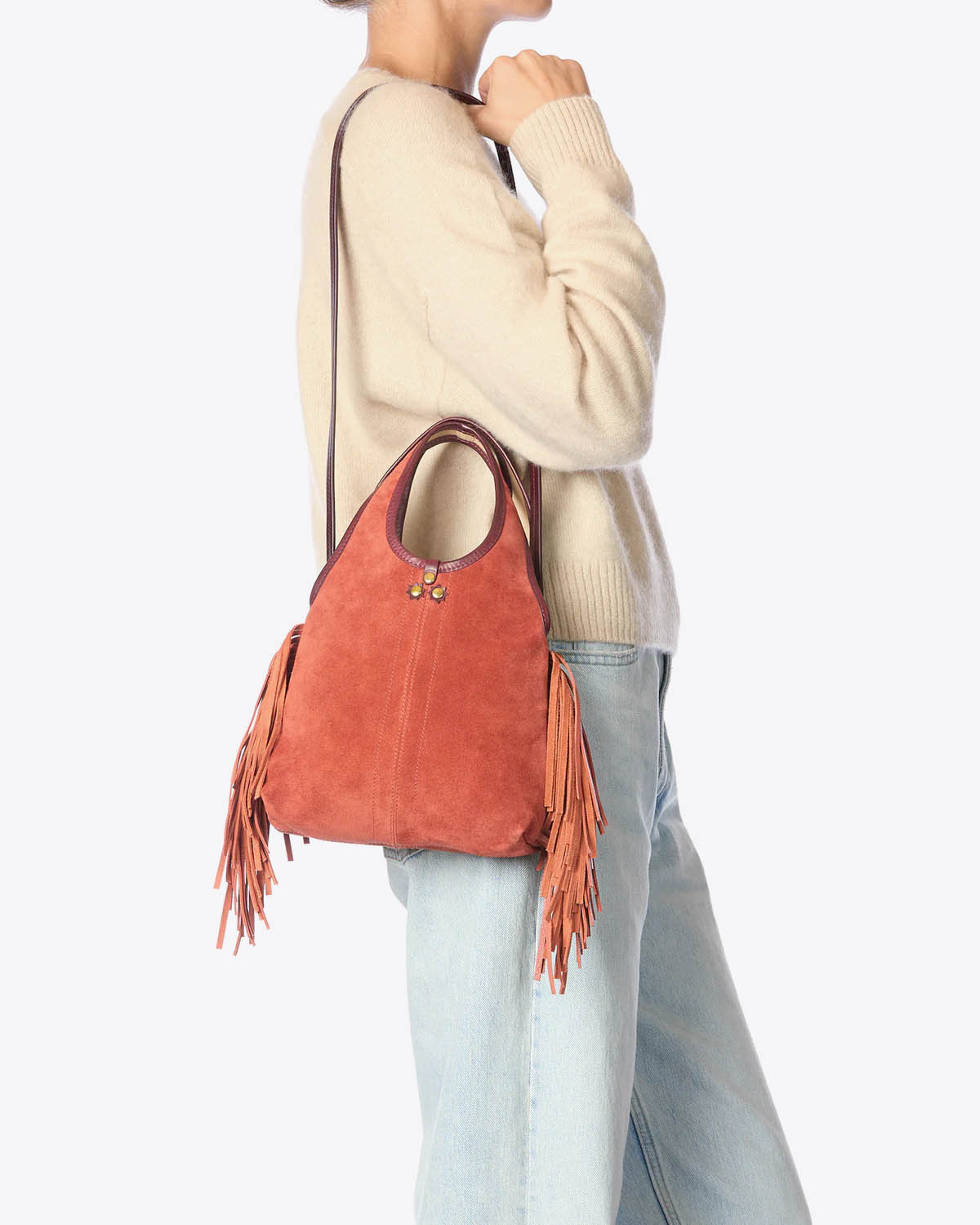 Mini-sac à franges bandoulière amovible en cuir suédé Haenyeo Terracotta Jérôme Dreyfuss. Capsule SS25. Vue porté épaule avec bandoulière. 