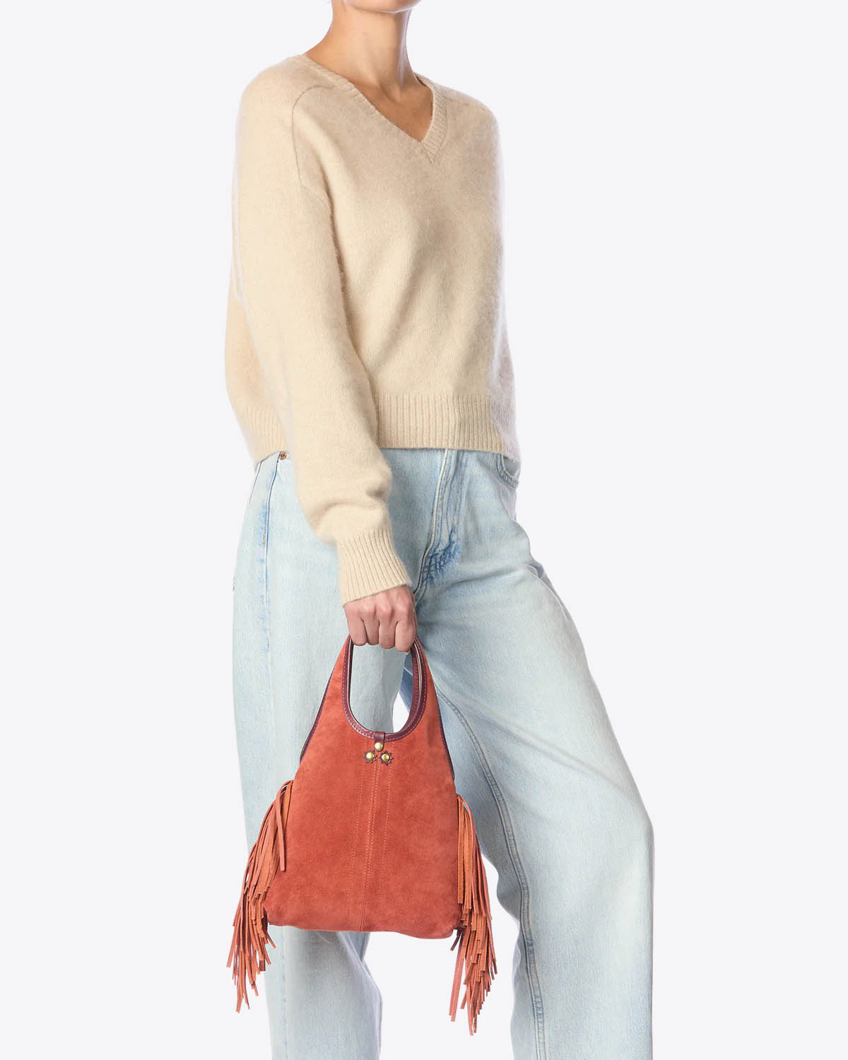 Mini-sac à franges bandoulière amovible en cuir suédé Haenyeo Terracotta Jérôme Dreyfuss. Capsule SS25. Vue porté à la main. 