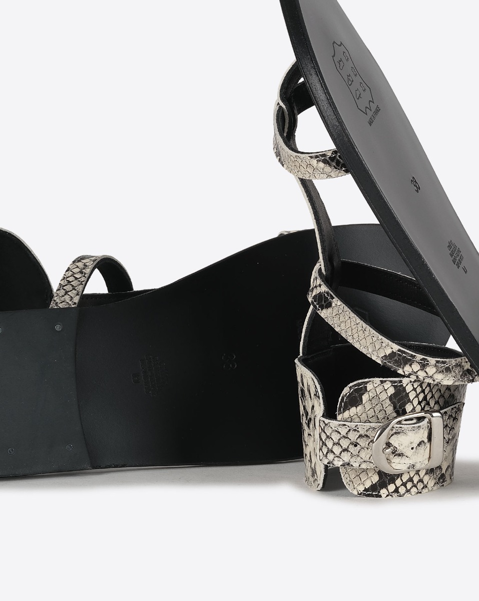 Sandales plates Caravelle K.Jacques St-Tropez en cuir effet python Kampal Duna. D&eacute;tail des semelles noires.