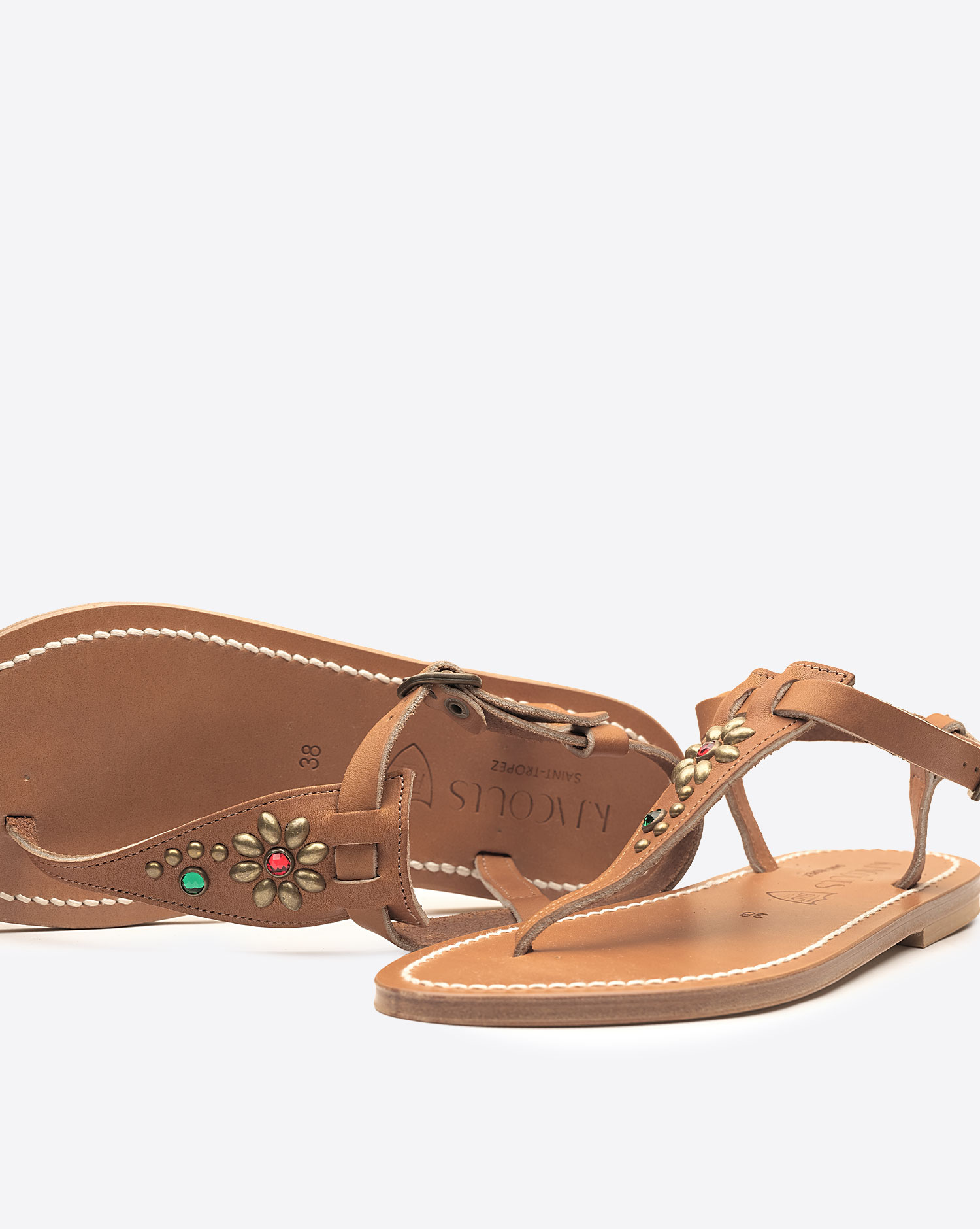 Sandales Coriolan K.Jacques x HTC en cuir noir, ornées de clous métalliques argentés et de pierres colorées formant une fleur, fabrication artisanale française. Détail des clous et pierres.