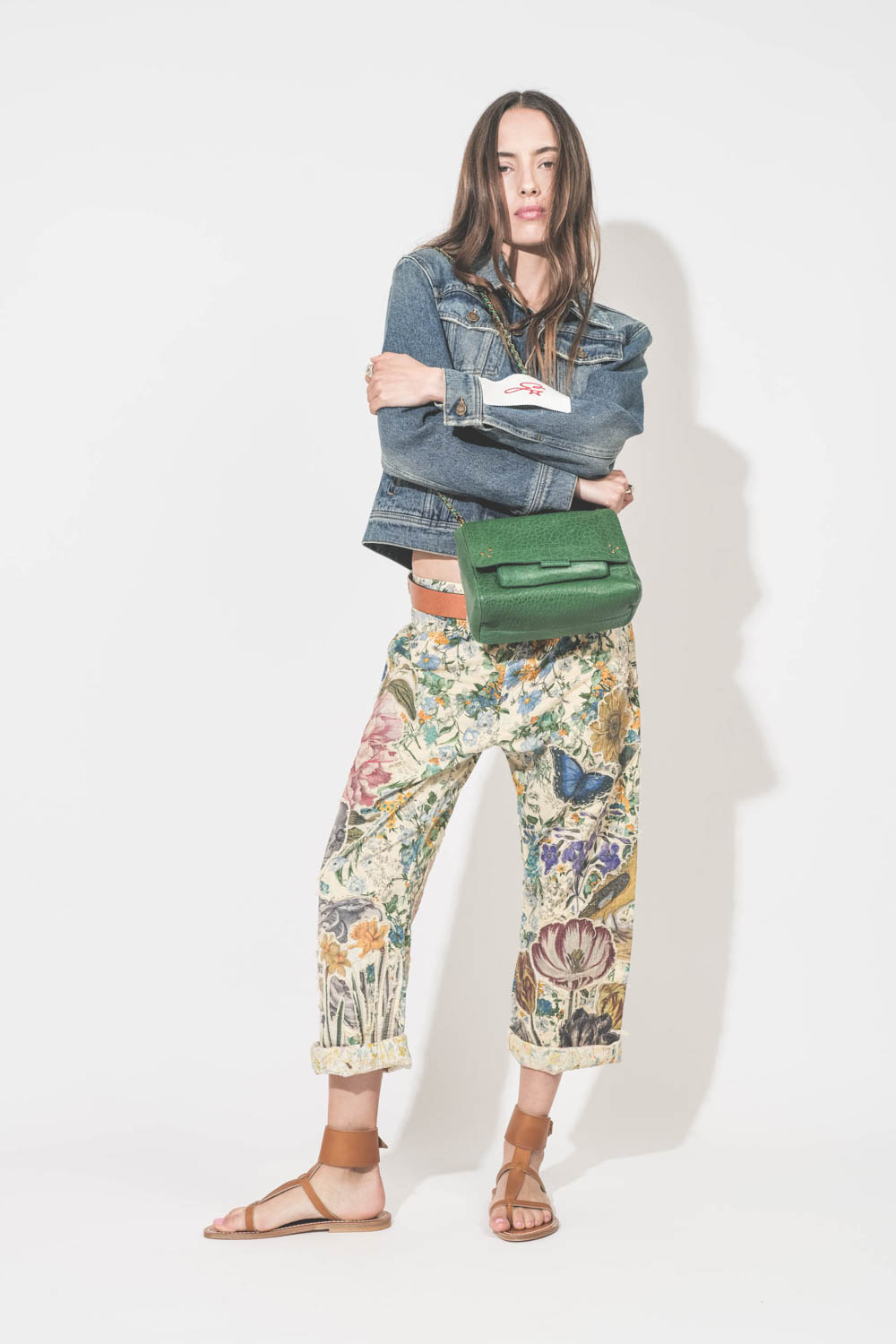 Sandales en cuir naturel large bracelet de cheville Caravelle pul naturel K.Jacques St-Tropez. Portées de profil avec un blouson en jean Golden Goose, un jean X-Boyfriend à fleurs R13 et une ceinture Dara cognac Isabel Marant. Sac Lulu M en cuir gazon Jér