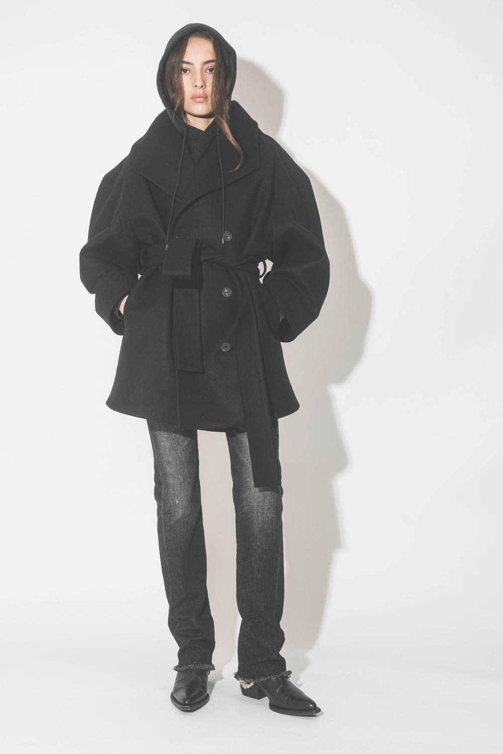 Manteau caban ceinturé en drap de laine noir Suzzane Vautrait. Porté avec un jeans noir.