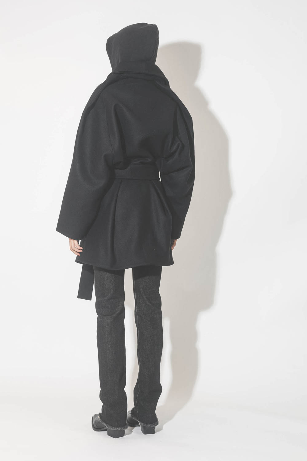 Manteau caban ceinturé en drap de laine noir Suzzane Vautrait. Porté de dos.