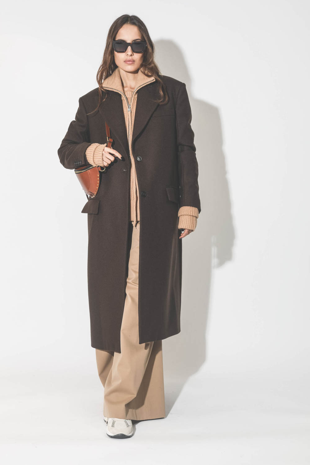 Manteau long en drap de laine marron Maison Flaneur. Poeté avec un pull camionneur en cachemire camel.