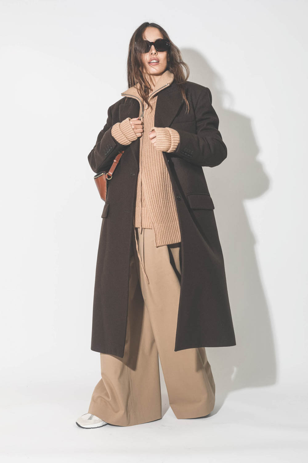 Manteau long en drap de laine marron Maison Flaneur. Porté avec un pantalon large camel.