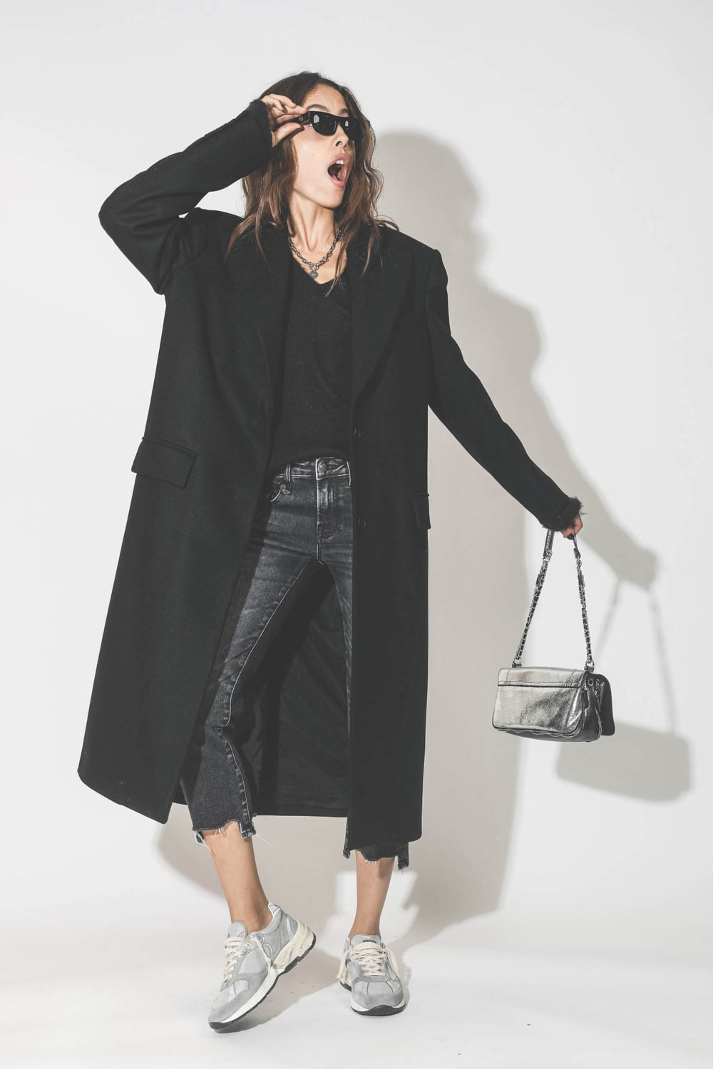 Manteau long en drap de laine noir Maison Flaneur. Porté avec un pull noir en mohair.