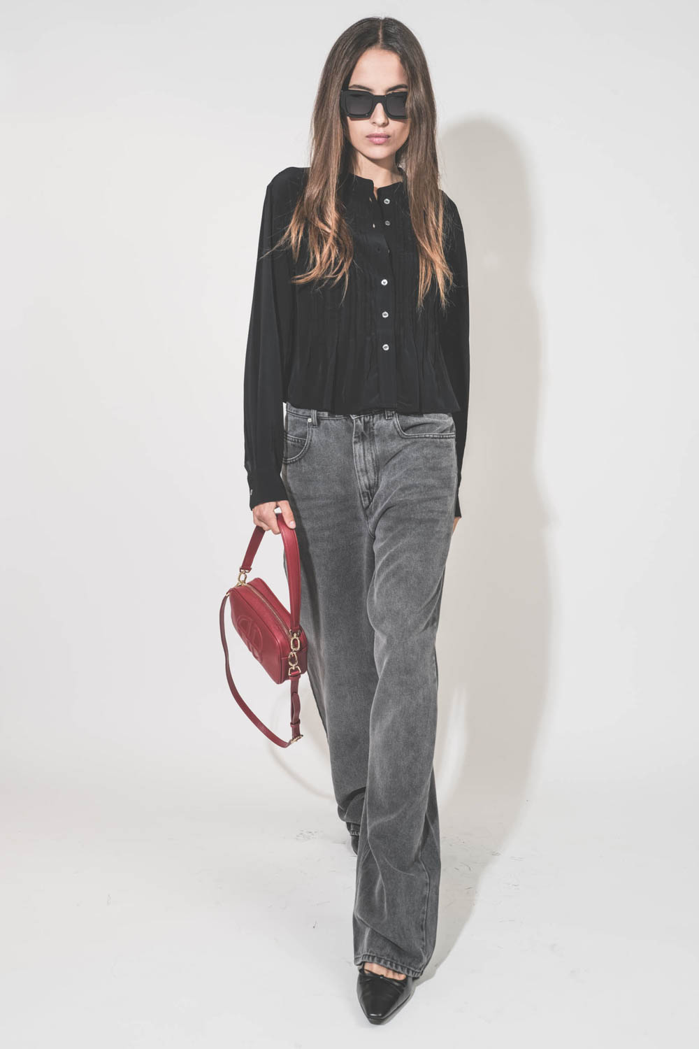 Jean large et fluide en Lyocell et coton gris clair Joanny Marant Etoile. Porté avec un top en viscose noir Adzara Marant Etoile et des escarpins à talons en cuir noir Freya Anine Bing. Sac Lili rouge et lunettes de soleil montures noires Indio AB Anine B
