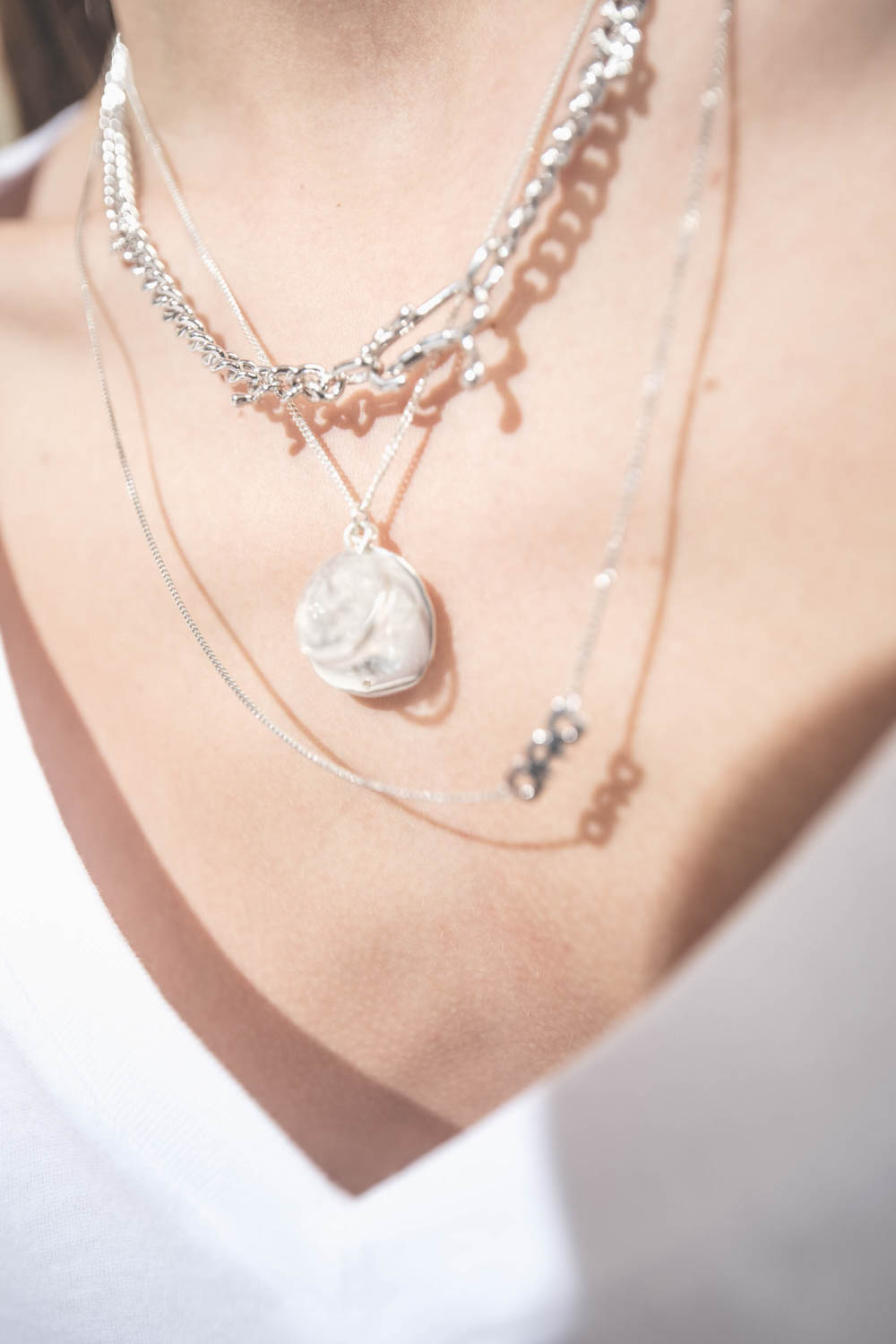 Collier long chaine avec lettre Dad en argent Maria Black. Porté en accumulation avec un collier chaine Berline en argent et un collier chaine et médailles L'amour en argent Pascale Monvoisin.