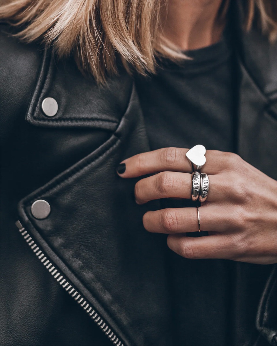 Bague Love Me Mikuta en argent, port&eacute;e en accumulation avec la bague Fuck Off et la bague c&oelig;ur Mikuta.