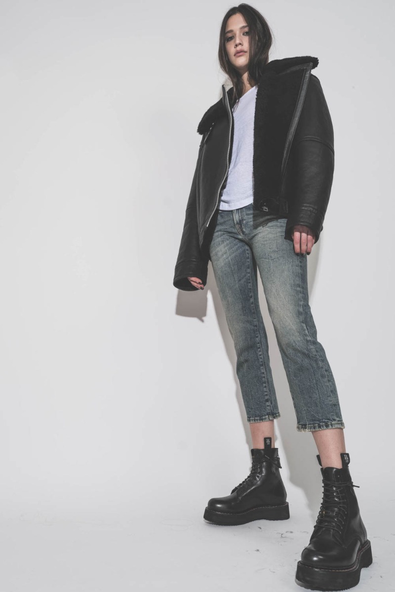 Blouson bombardier Mikuta en cuir et peau de mouton noir ultra-chaude, porté de face avec un jean bleu R13.