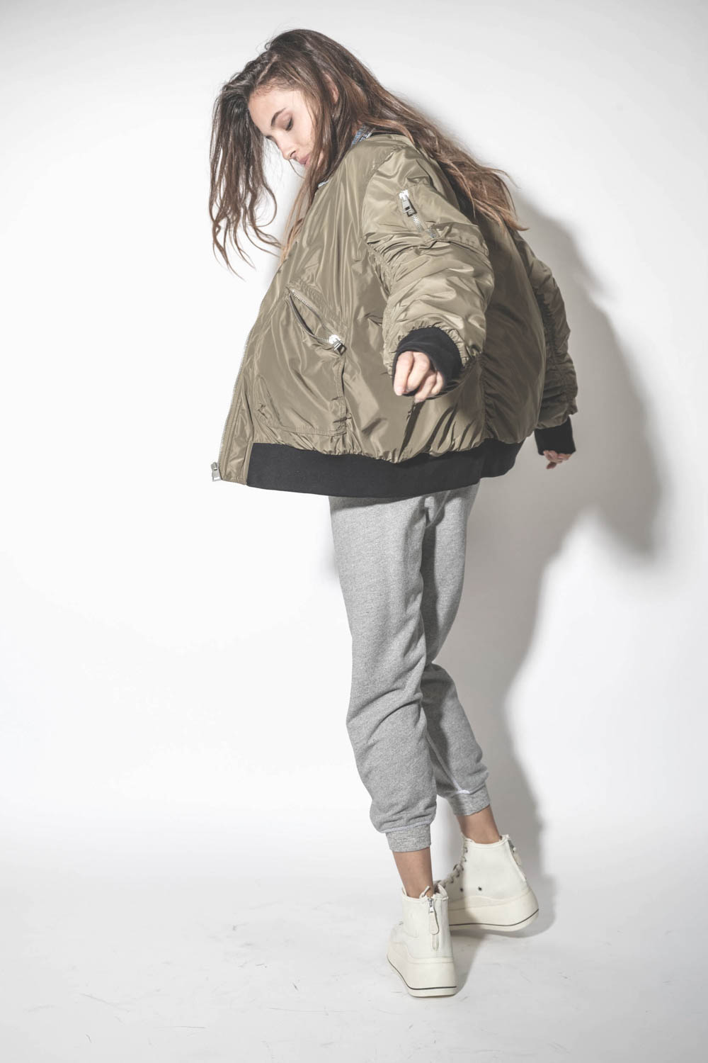 Blouson Bomber aviateur kaki Mikuta. Porté avec un pantalon de jogging gris chiné.