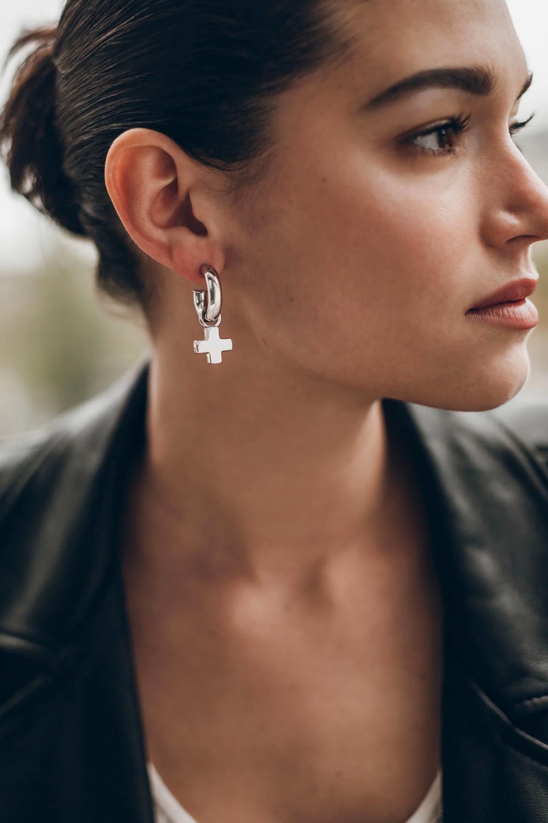 Boucles d'oreilles mini-cr&eacute;oles Mikuta en argent, port&eacute;e de face avec un pendentif croix.