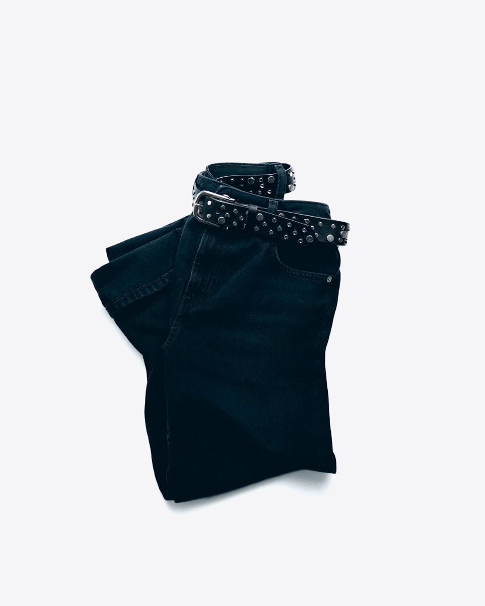 Ceinture Mikuta en cuir noir clouté, portée sur un jean noir.