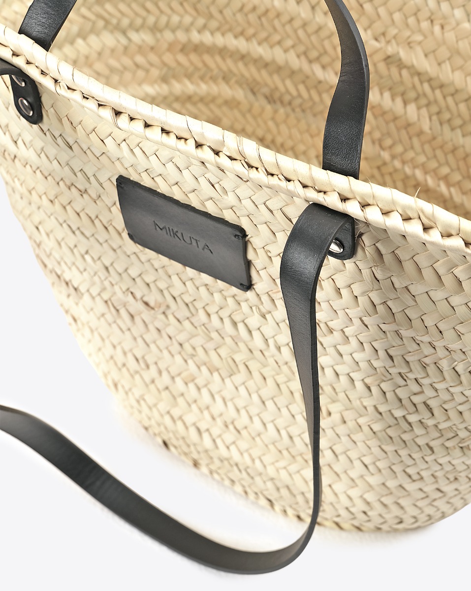Grand panier en osier naturel Mikuta. D&eacute;tail du patch en cuir &laquo; MIKUTA &raquo; su le devant.