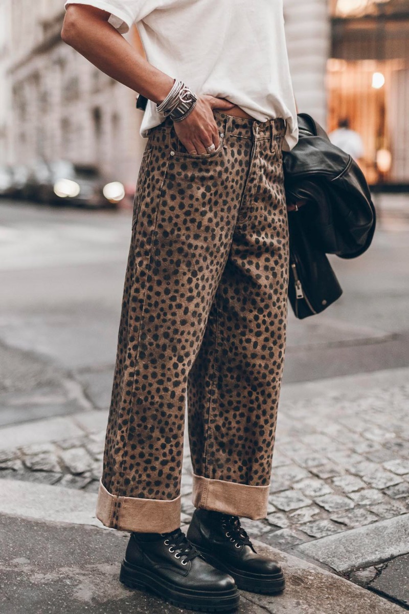 Jean baggy Mikuta en jean imprimé léopard marron, porté avec un large revers.