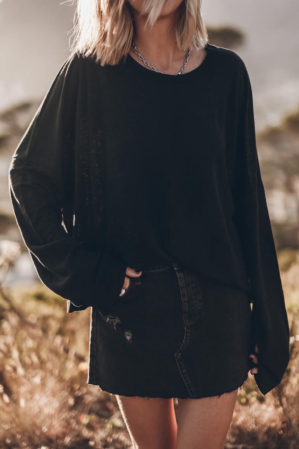 Produit Minu Jupe en jean Mikuta en denim noir. Vue face porté avec un tee-shirt manches longues oversize. 