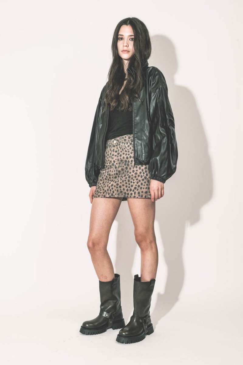 Mini-jupe en jean imprimée léopard marron Mikuta. Portée de profil avec  un blouson en sky noir Marant Étoile.