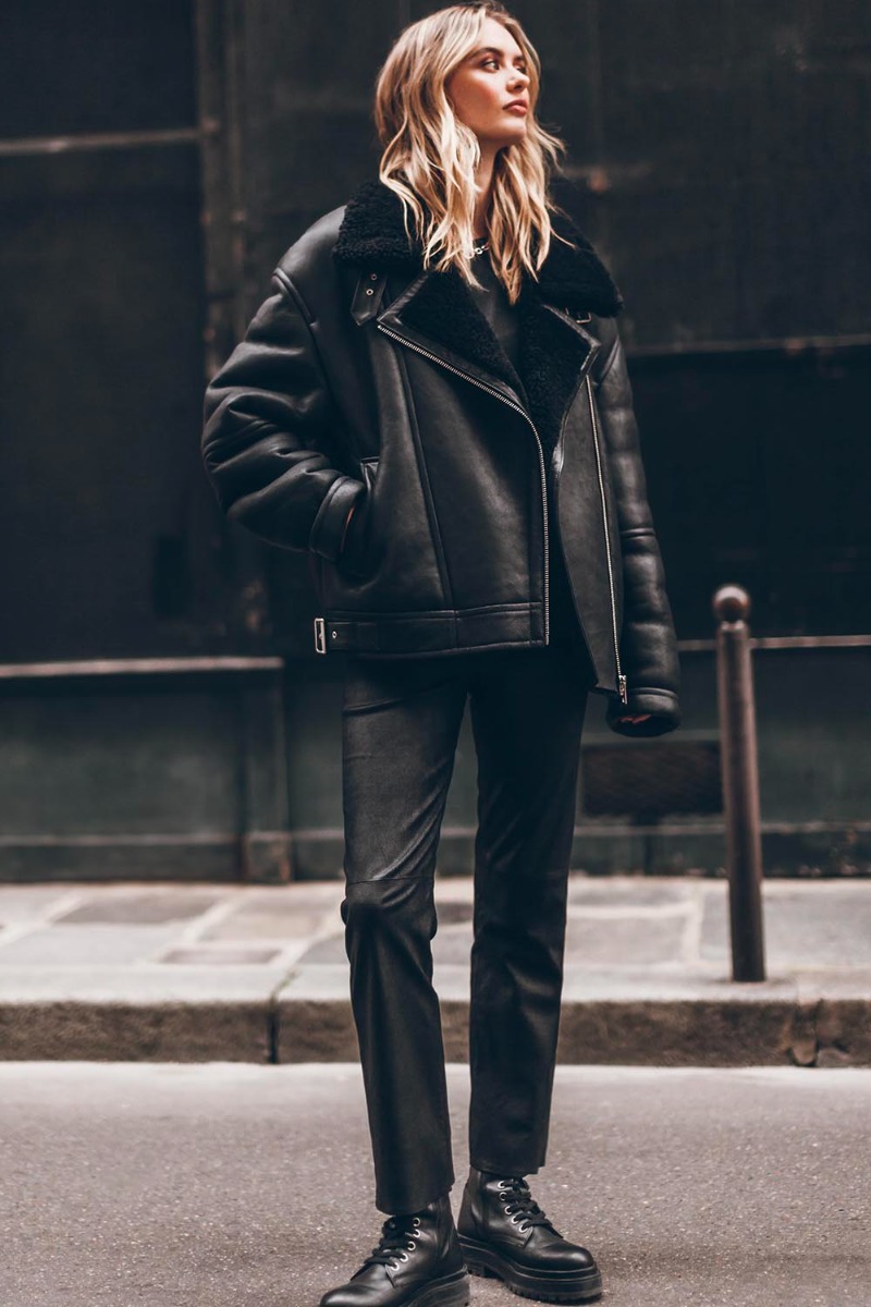 Blouson bombardier Mikuta en cuir et peau de mouton noir ultra-chaude, porté avec un jean noir.