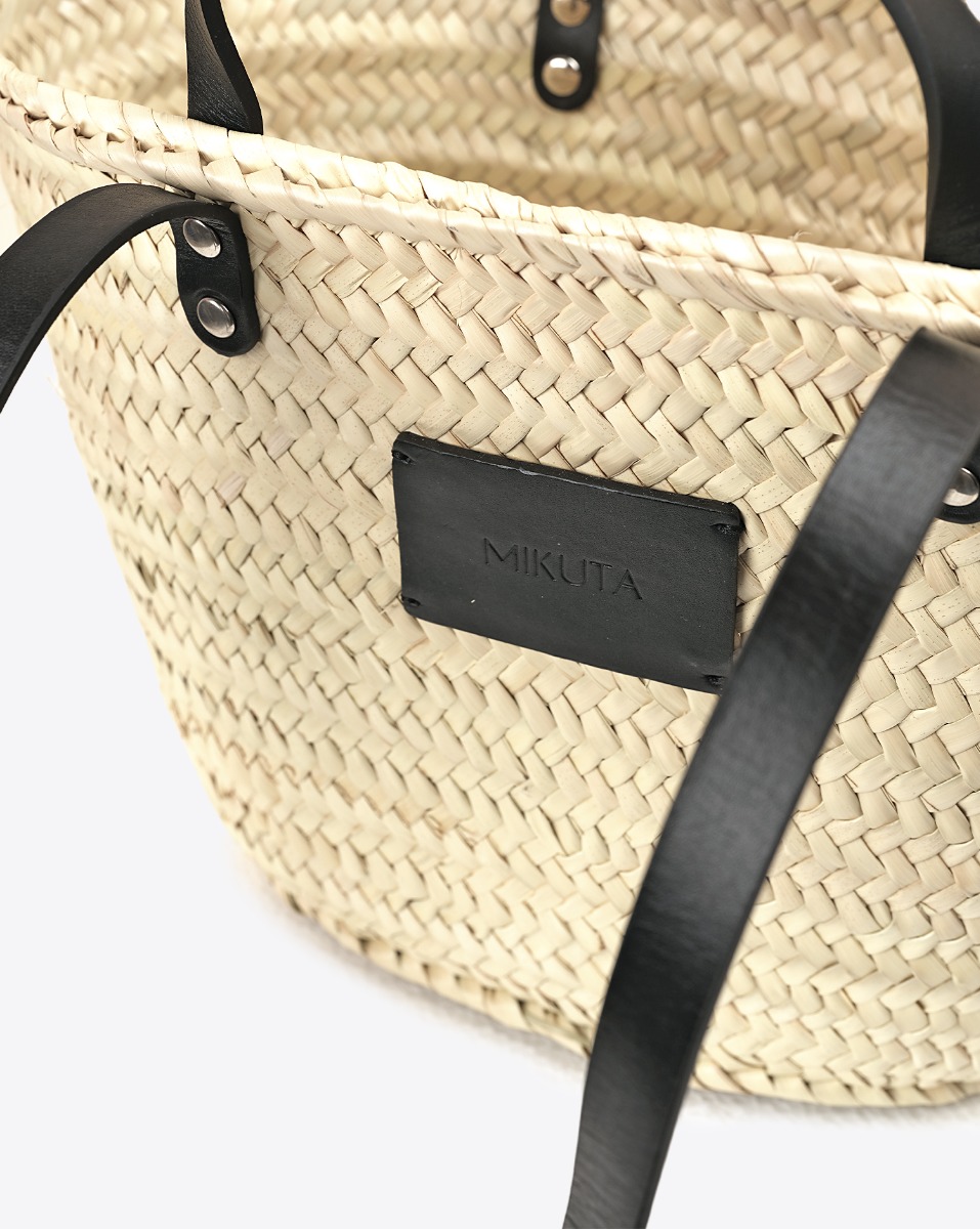 Petit panier en osier Mikuta. D&eacute;tail du patch en cuir noir &laquo; MIKUTA &raquo; sur le devant.