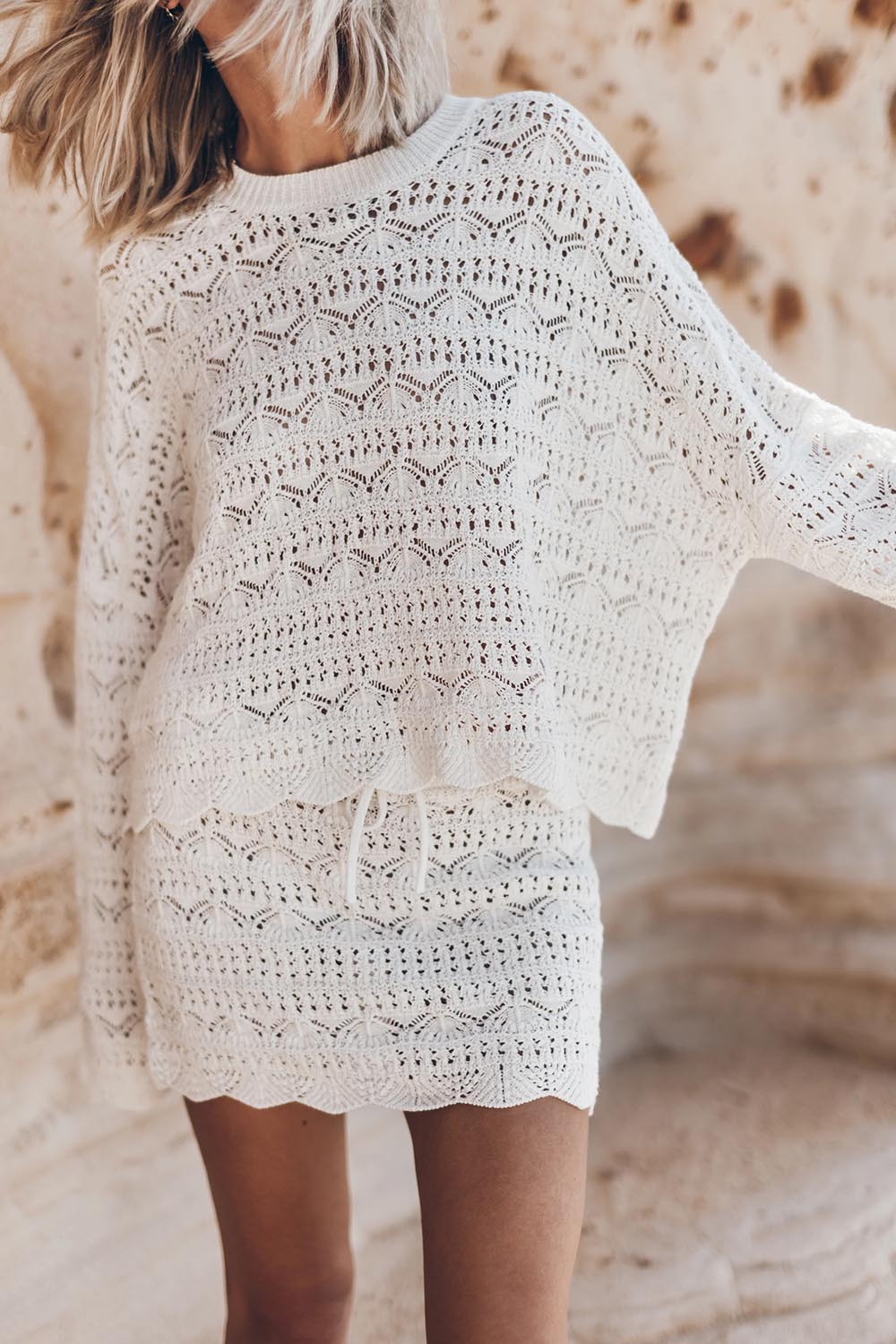 Produit Pull manches longues col rond en crochet in et coton écru Mikuta. Porté de face avec une mini-jupe en crochet assortie.