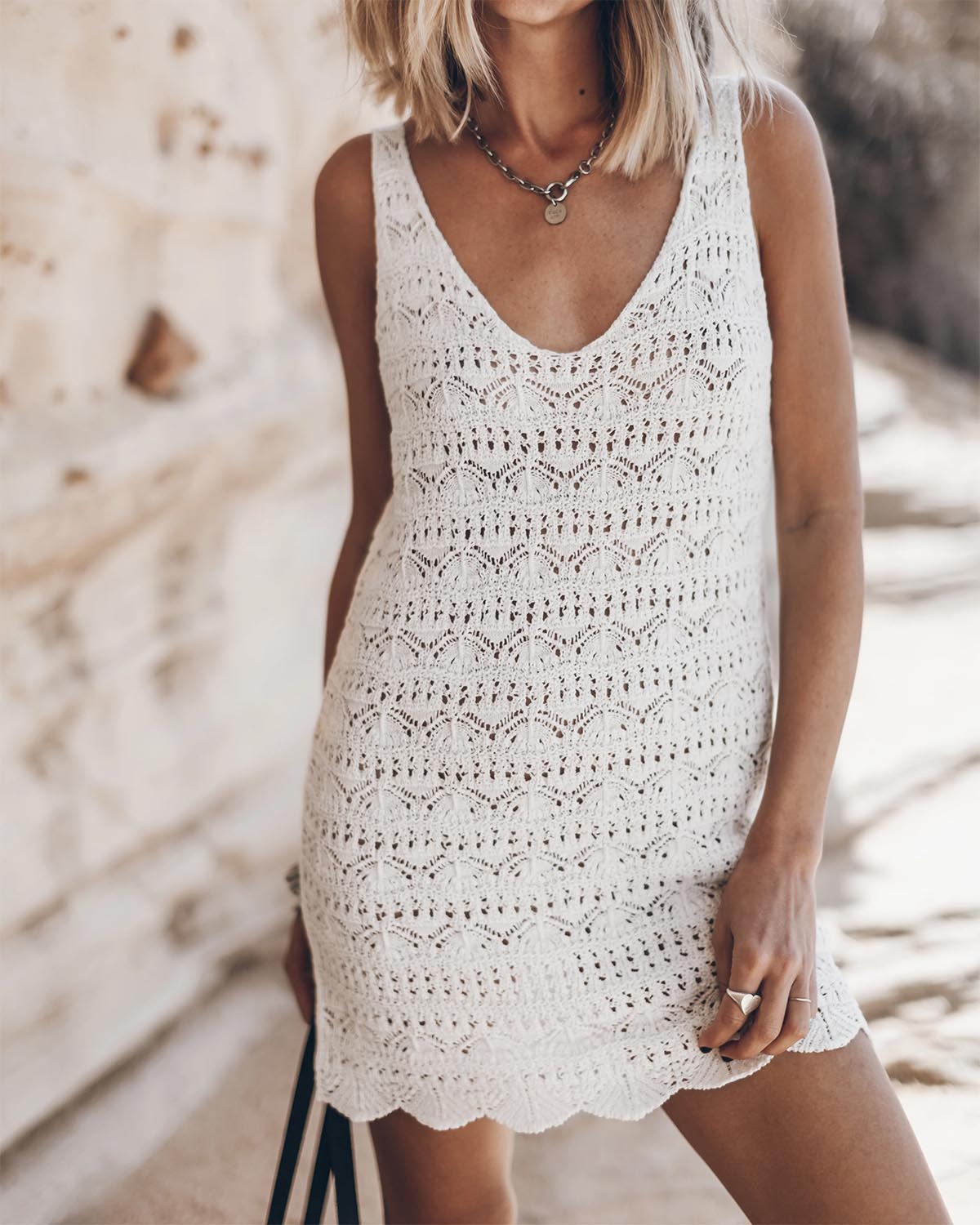 Robe débardeur en crochet écru en lin et coton Mikuta. Portée avec un collier en argent Mikuta. 