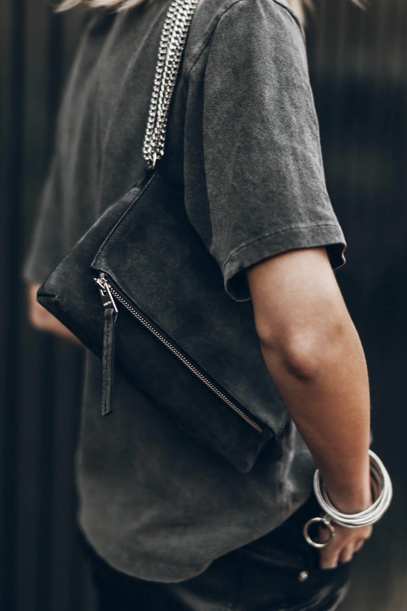 Sac Zowie Mikuta en cuir su&eacute;d&eacute; noir et chaine en m&eacute;tal argent&eacute;, port&eacute; &agrave; l'&eacute;paule.