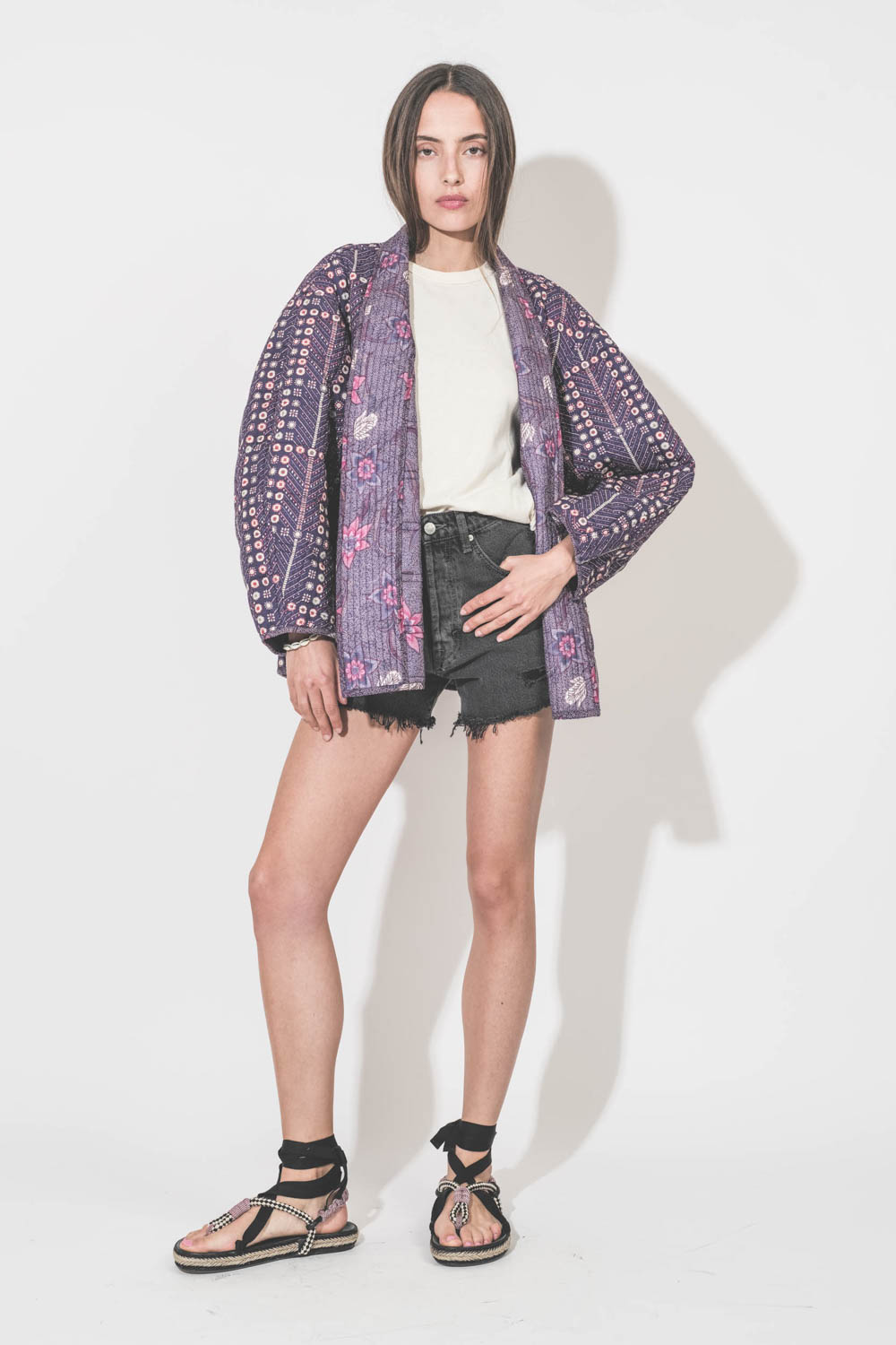 Short taille haute en jean noir Mikuta. Porté de face avec un tee-shirt Boxy Crew écru The Great, une veste Chancel Marant Etoile et des sandales Gypsa noir Isabel Marant.