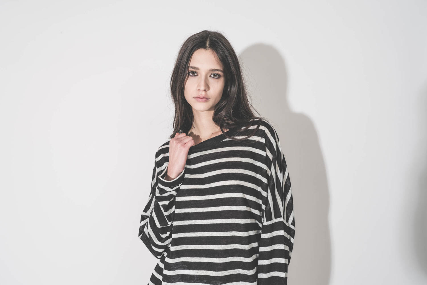 T-shirt Oversized Mikuta &agrave; manches longues en lin ray&eacute; noir et blanc, port&eacute; de face. D&eacute;tail du col noir.