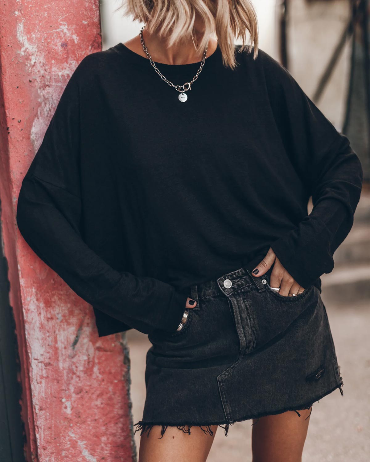 Tee-shirt Oversized Mikuta en lin noir. Vue face porté avec une jupe en denim noir. 