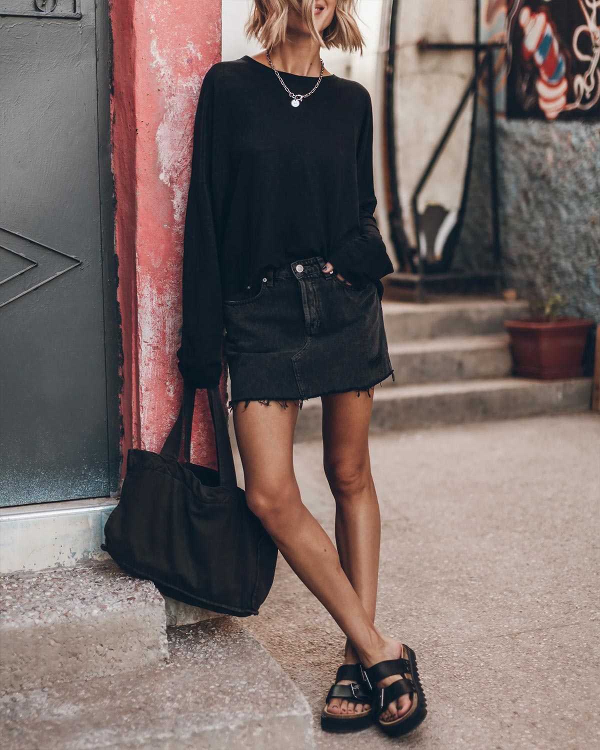 Tee-shirt Oversized Mikuta en lin noir. Vue face porté avec une jupe en denim noir. 