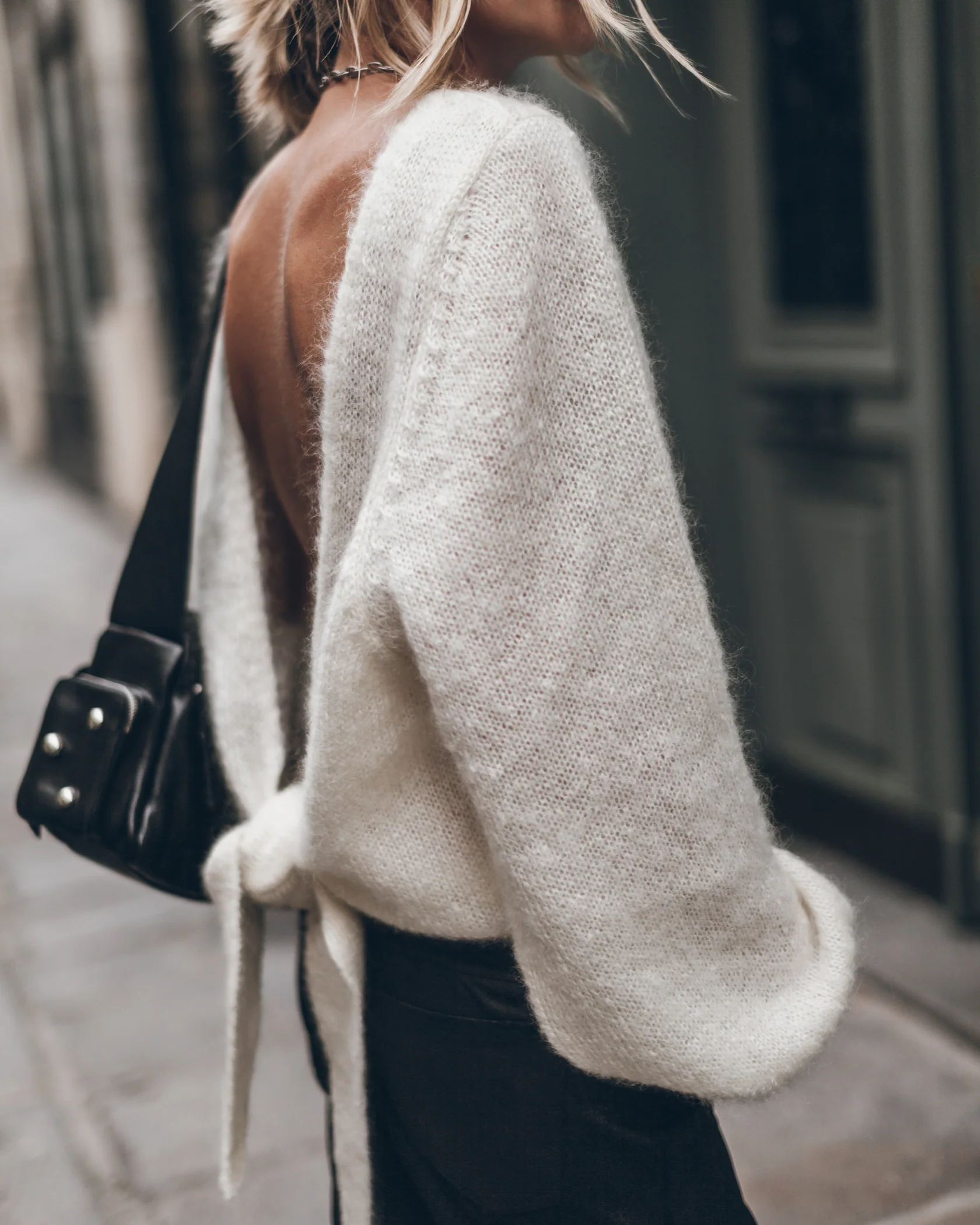 Pull dos-nu Mikuta en mohair écru noué dans le dos, porté de profil.