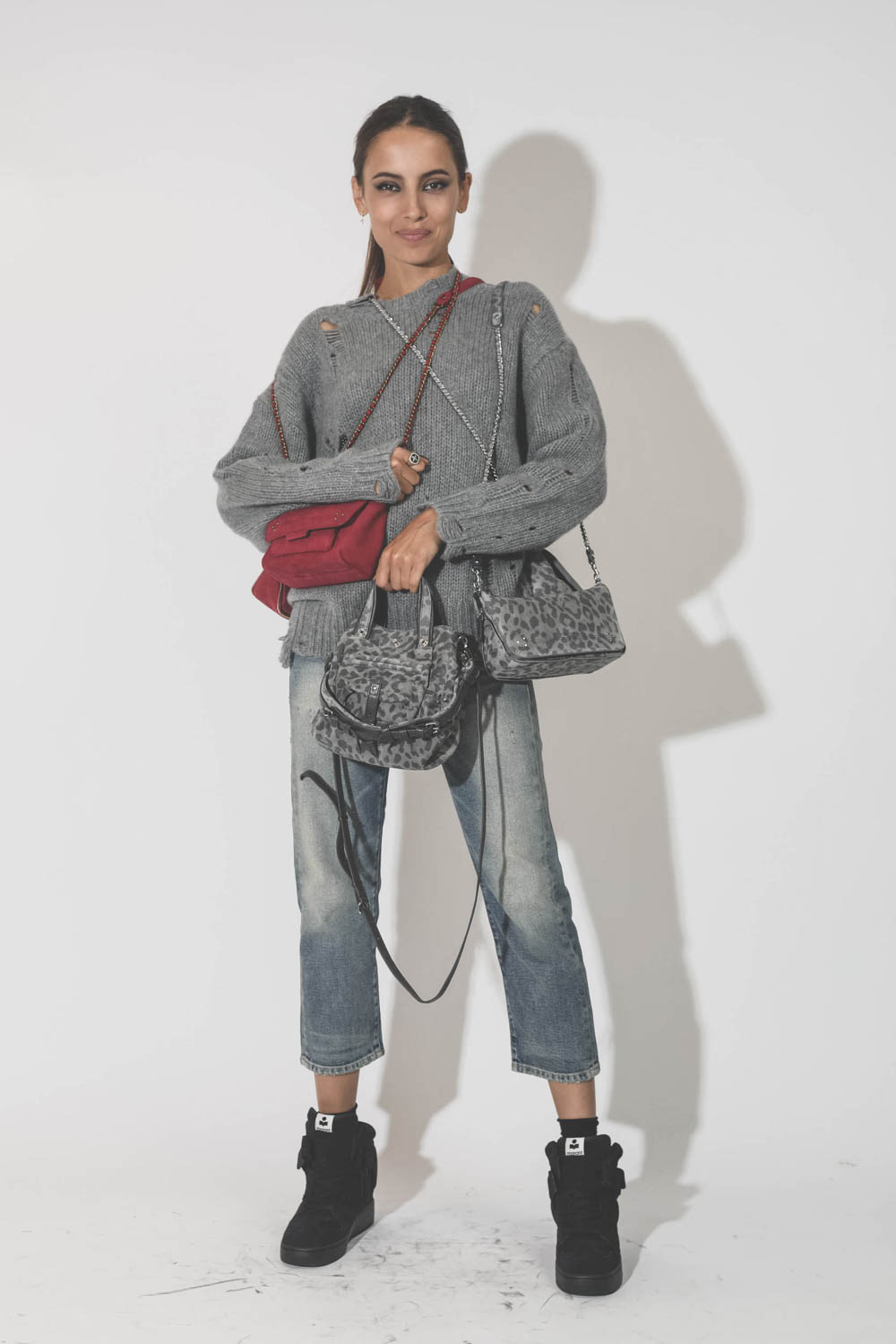 Pull oversize en cachemire démaillé gris r13. Porté avec une accumulation de sacs.