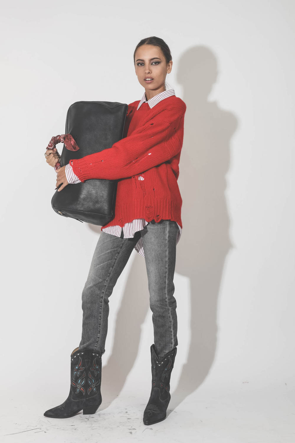 Pull oversize en cachemire démaillé épais rouge r13. Porté avec un jeans gris.