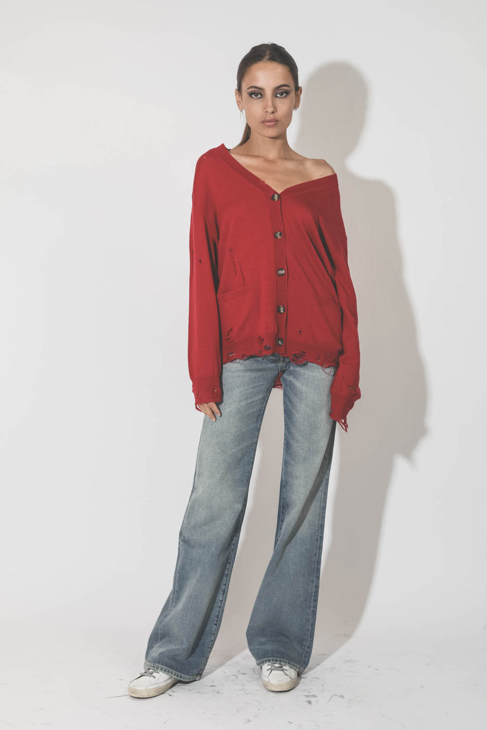Gilet col V démaillé en 100% cachemire rouge R13. Porté de face.