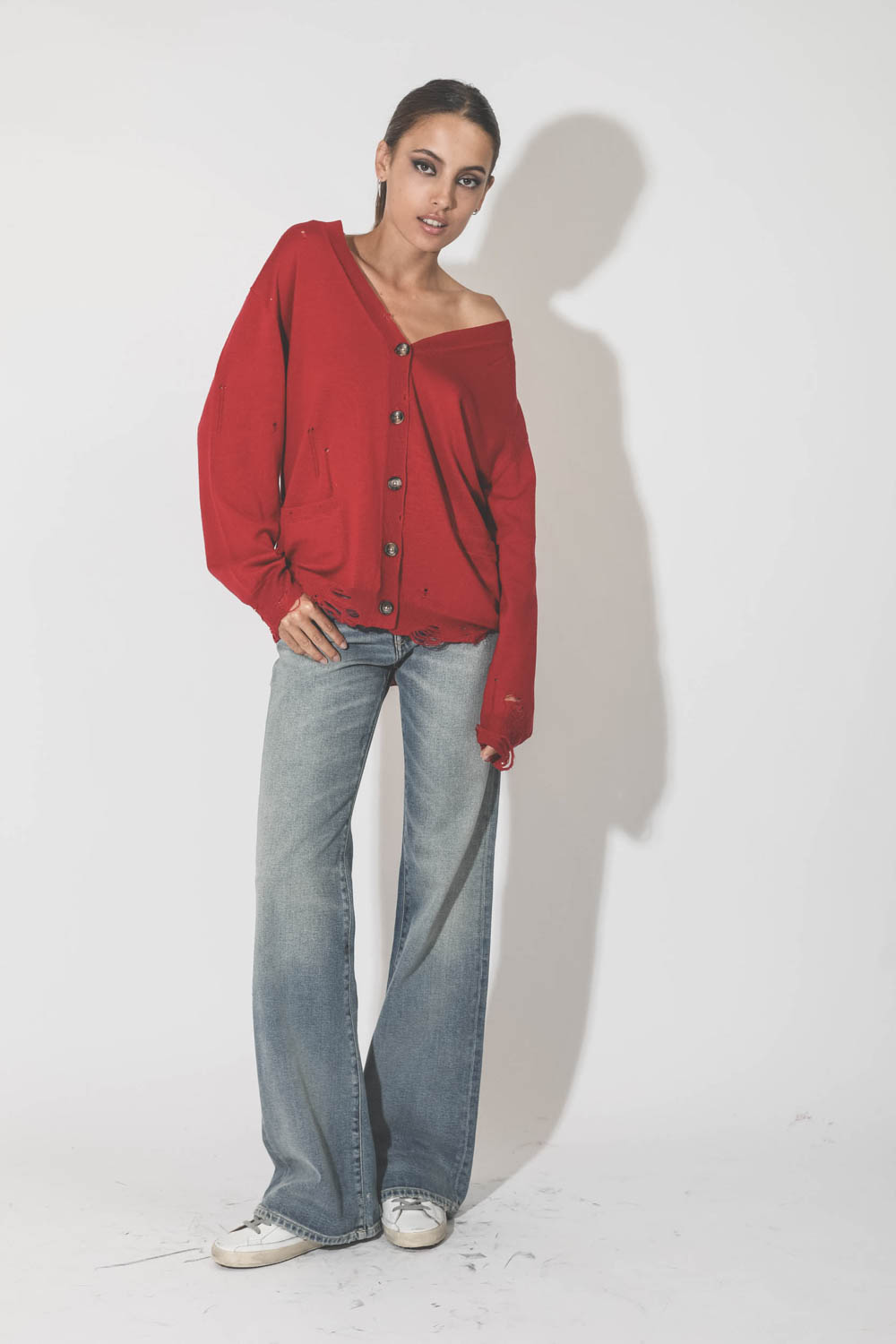 Gilet col V démaillé en 100% cachemire rouge R13. Porté loose.