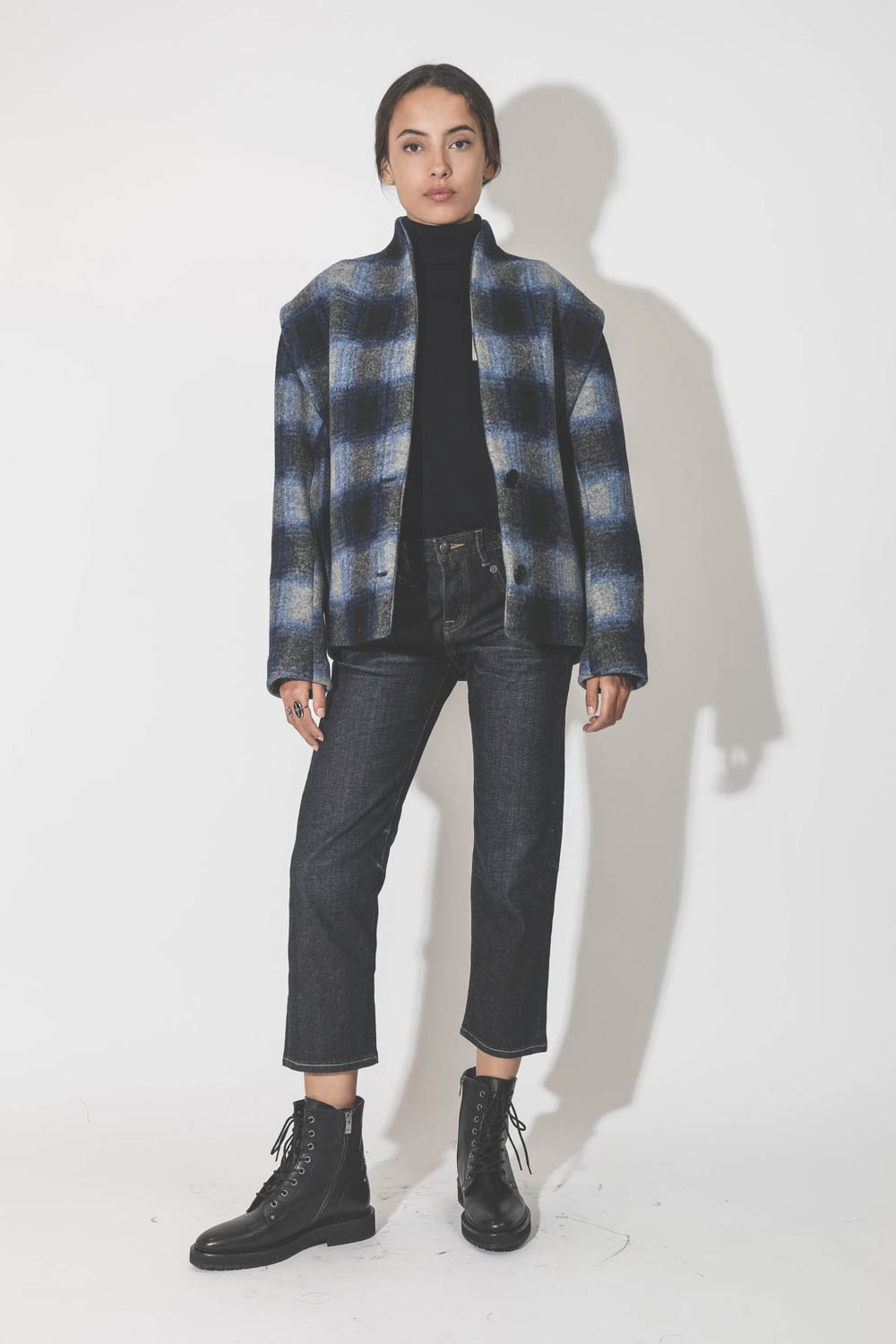 Pull col roulé en coton et laine bleu marine foncé avec logo Nash Marant Etoile. Porté avec une veste à carreaux bleus.