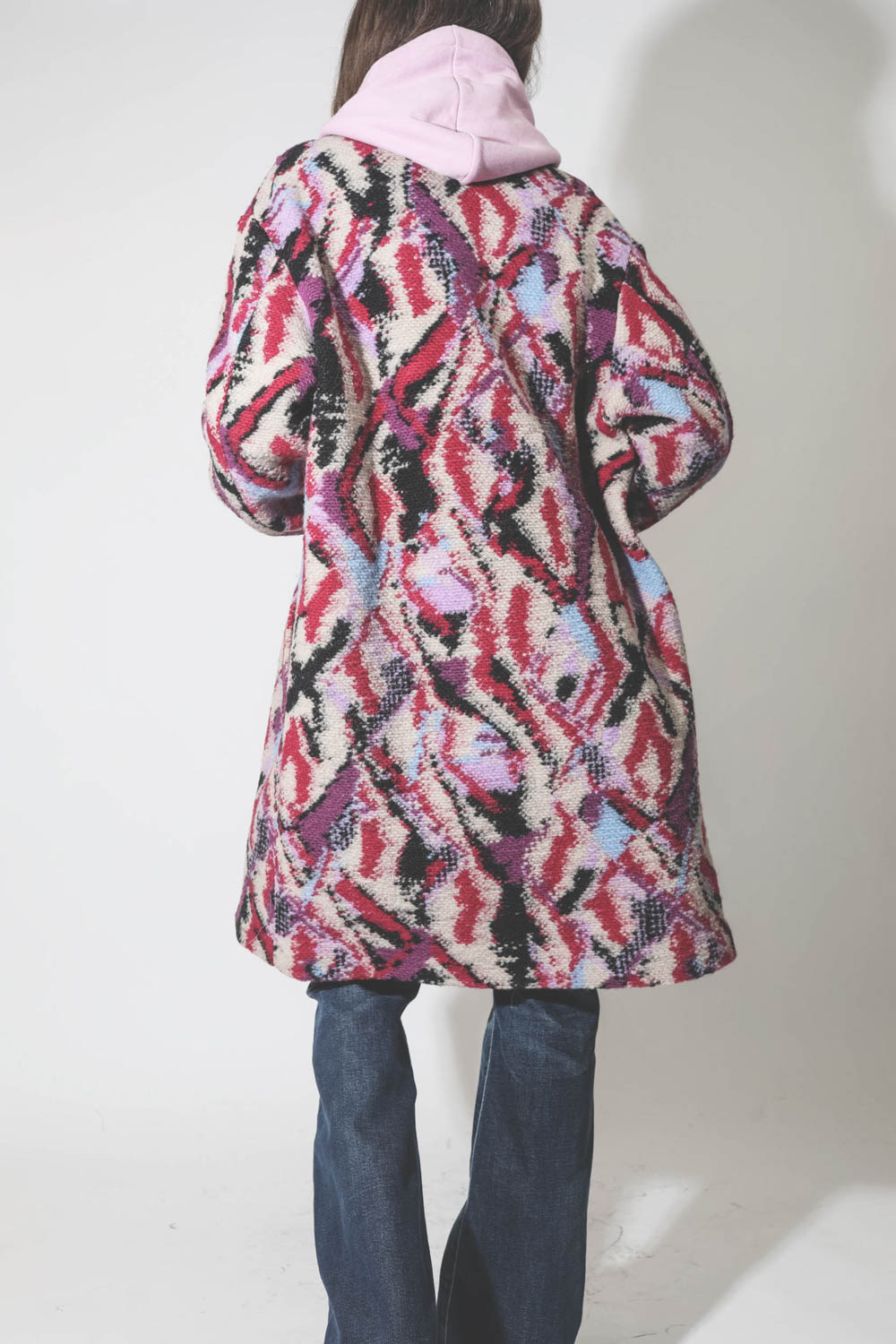 Manteau imprimé jacquard rose fond écru Sharon Marant Etoile. Porté avec un jean évasé.