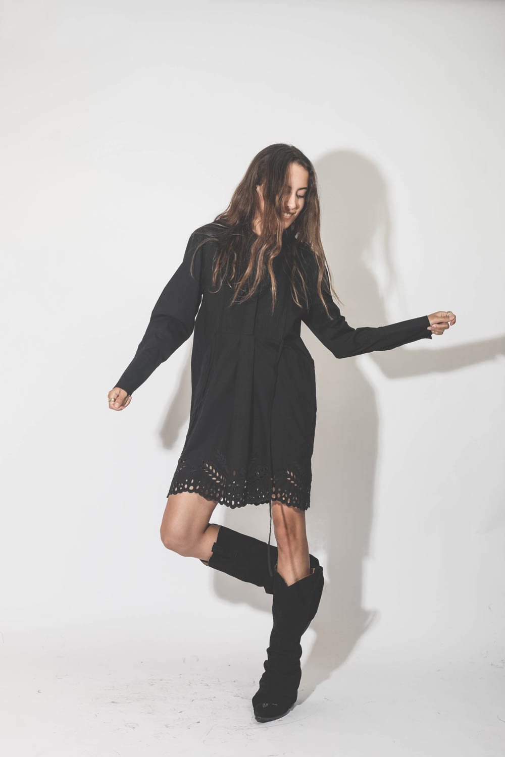 Robe manches longues au dessus du genoux en popeline noire et dentelle Rehanna Marant Etoile. Porté avec des bottes en cuir suédé noir.
