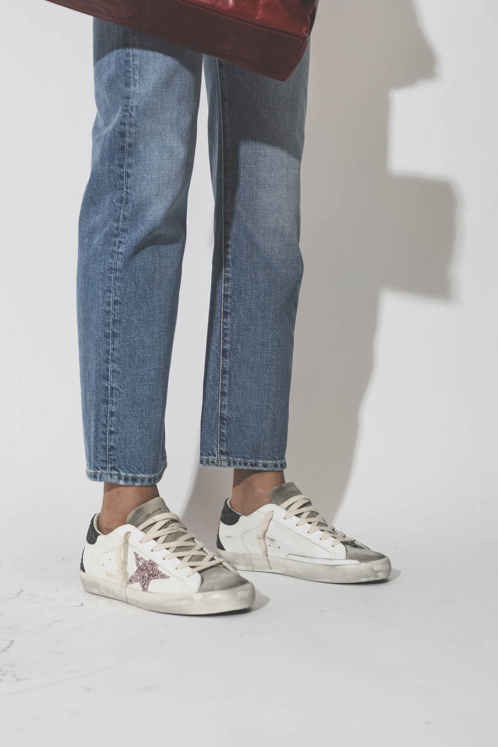Sneakers Superstar étoile à paillettes roses arrière à paillettes noires Golden Goose. Porté de face. 
