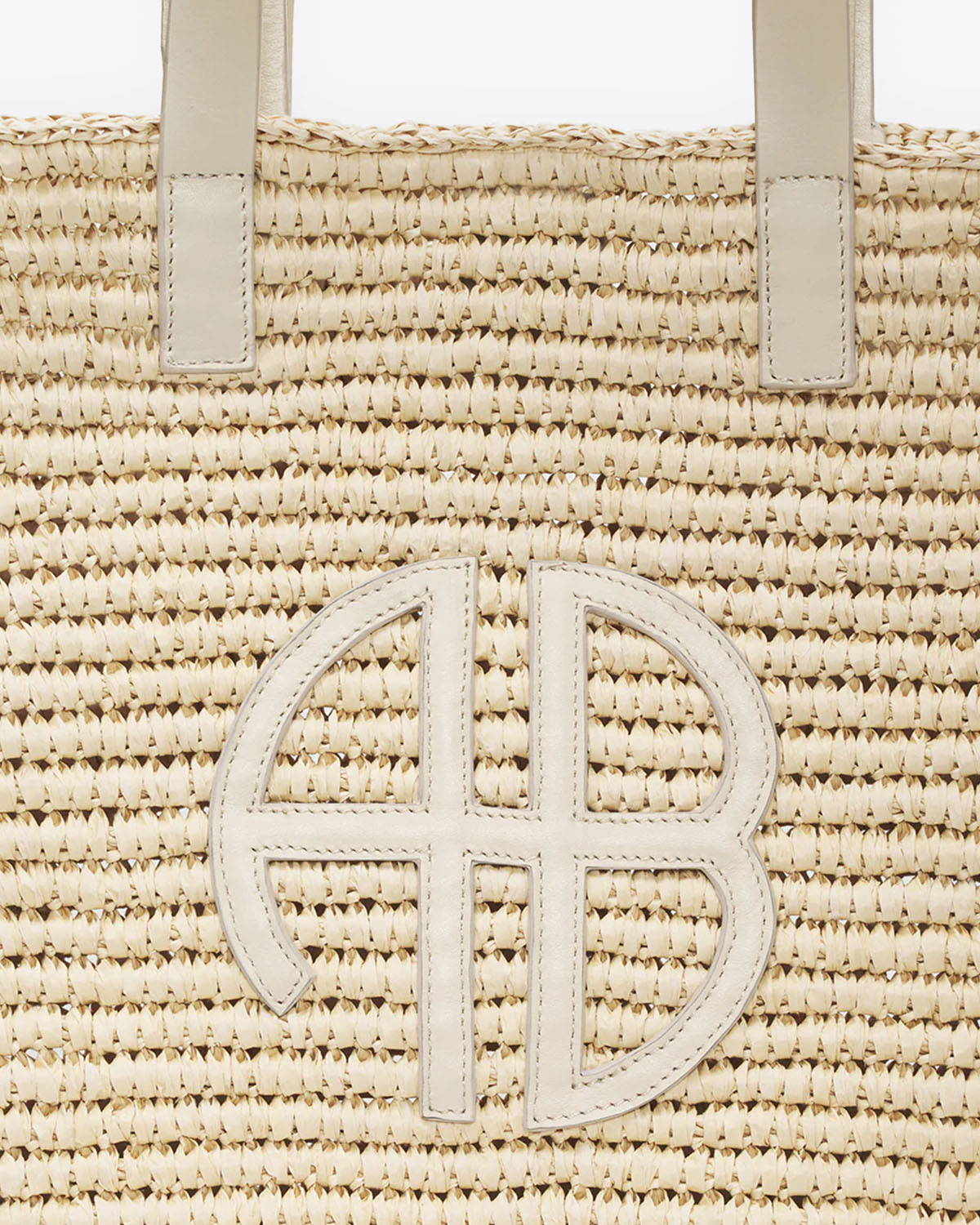 Panier en osier naturel anses et logo AB en cuir ivoire Palermo Anine Bing. Détail du logo AB en cuir ivoire.