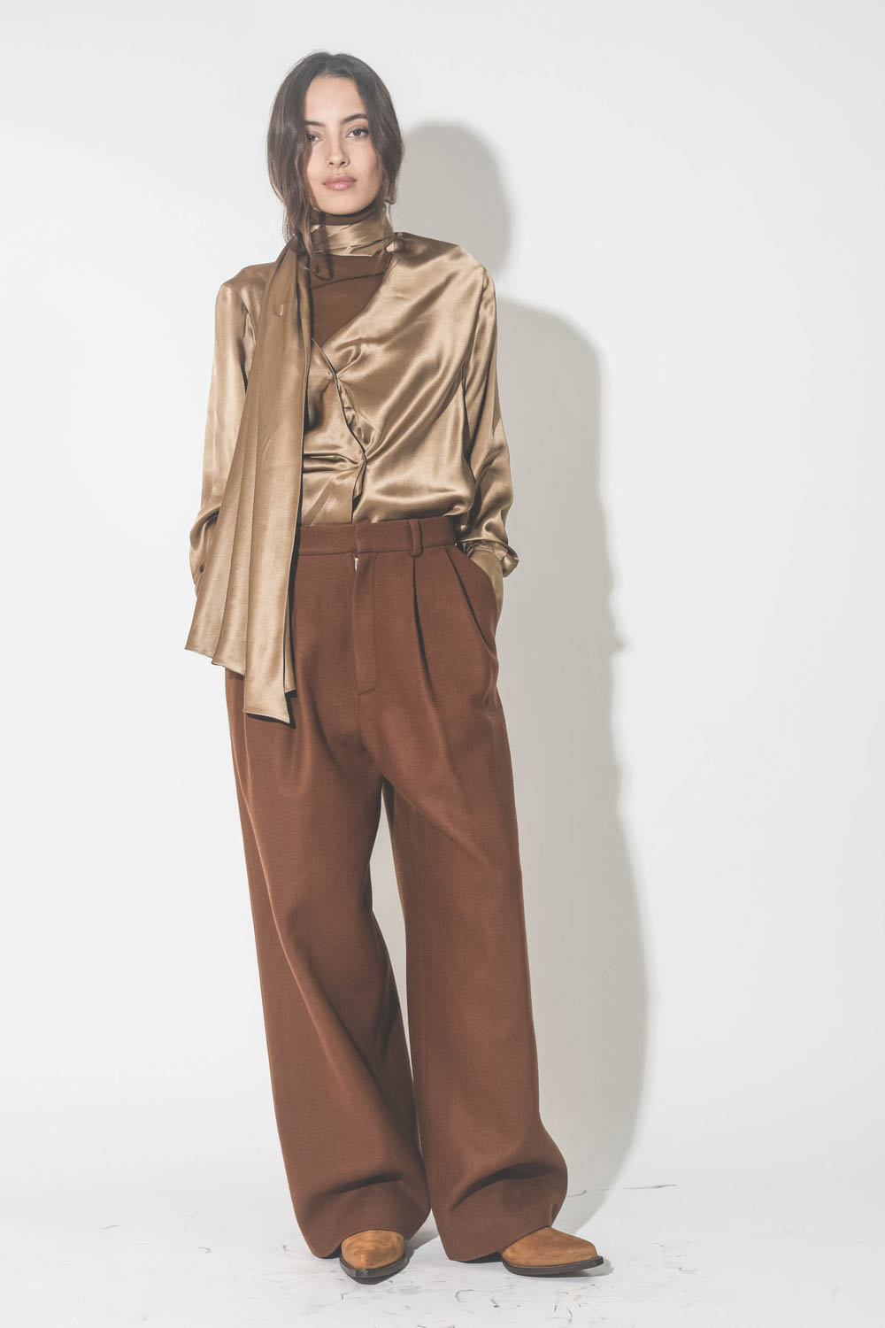 Pantalon large à pinces en drap de laine marron Vautrait. Porté avec une blouse en soie camel dorée.