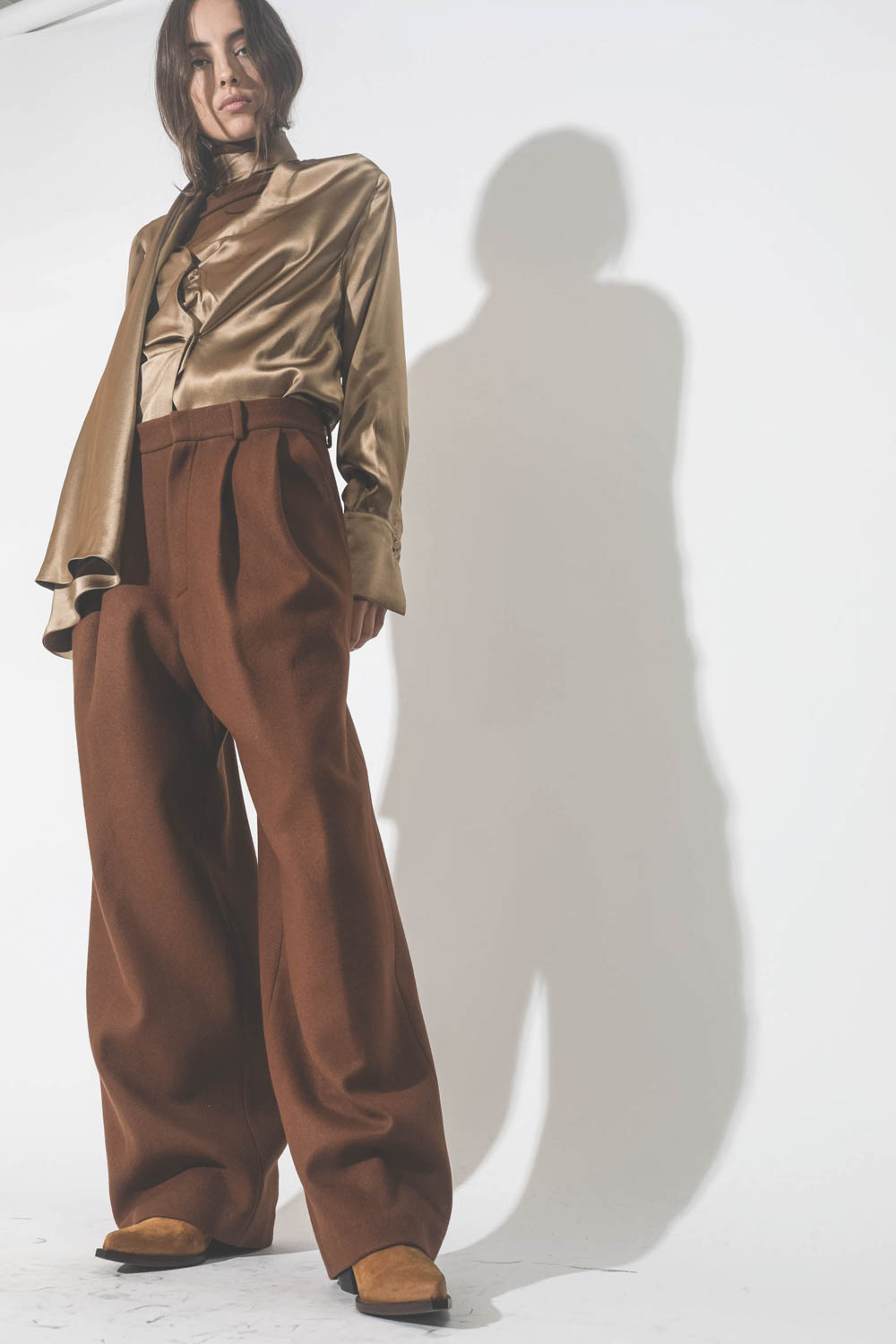 Pantalon large à pinces en drap de laine marron Vautrait. Porté avec des boots santiags camel.