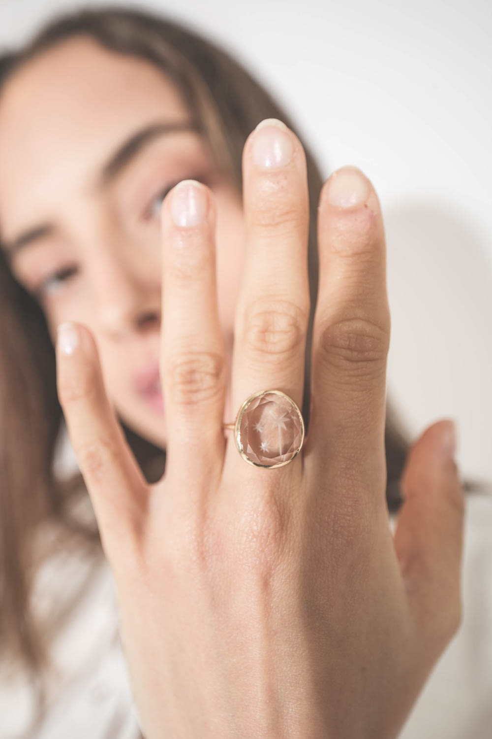 Bague ronde monture en or jaune gravé "Forever is composed of nows"  citation d'Emily Dickinson et cristal de roche gravé d'un palmier Alba Pascale Monvoisin. Portée de face au majeur. 
