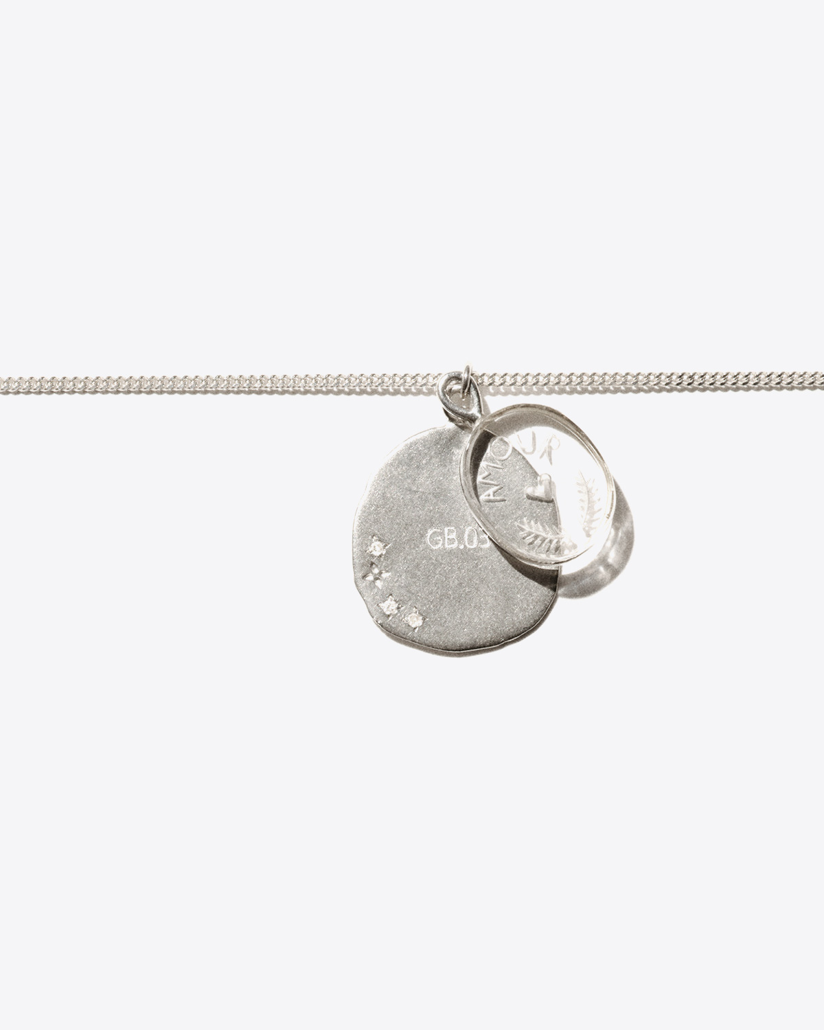 Collier en argent avec deux médailles, une en argent serti de diamants et une en cristal de roche gravé "AMOUR" L'amour pendentif Pascale Monvoisin. Détail des médailles.