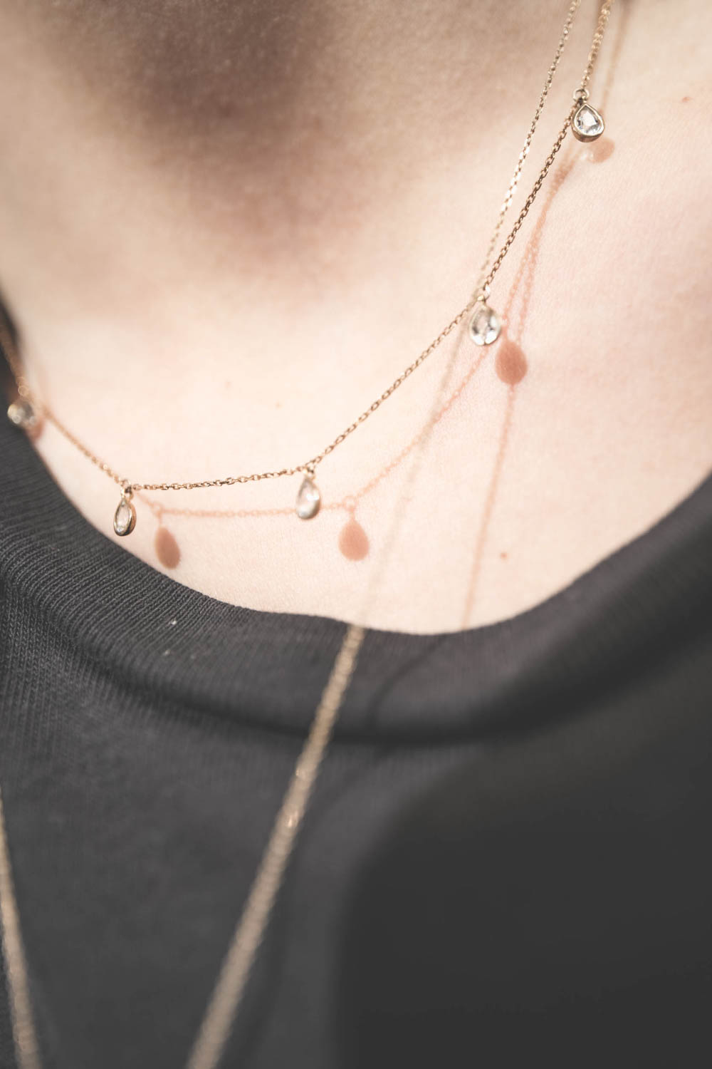Collier chaine et pampilles en or jaune et saphir blanc Palerme Pascale Monvoisin. Porté avec le collier chaine et médaille Rio N°2 Pascale Monvoisin. Tee-shirt noir Boxy Crew The Great.