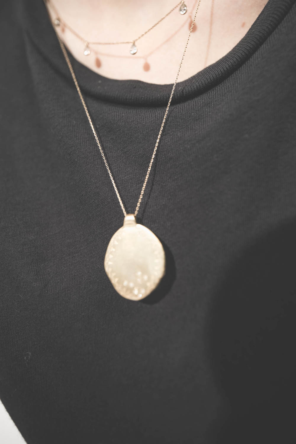 Collier chaine et pampilles en or jaune et saphir blanc Palerme Pascale Monvoisin. Porté de face avec le collier chaine et médaille Rio N°2 Pascale Monvoisin. Tee-shirt noir Boxy Crew The Great.