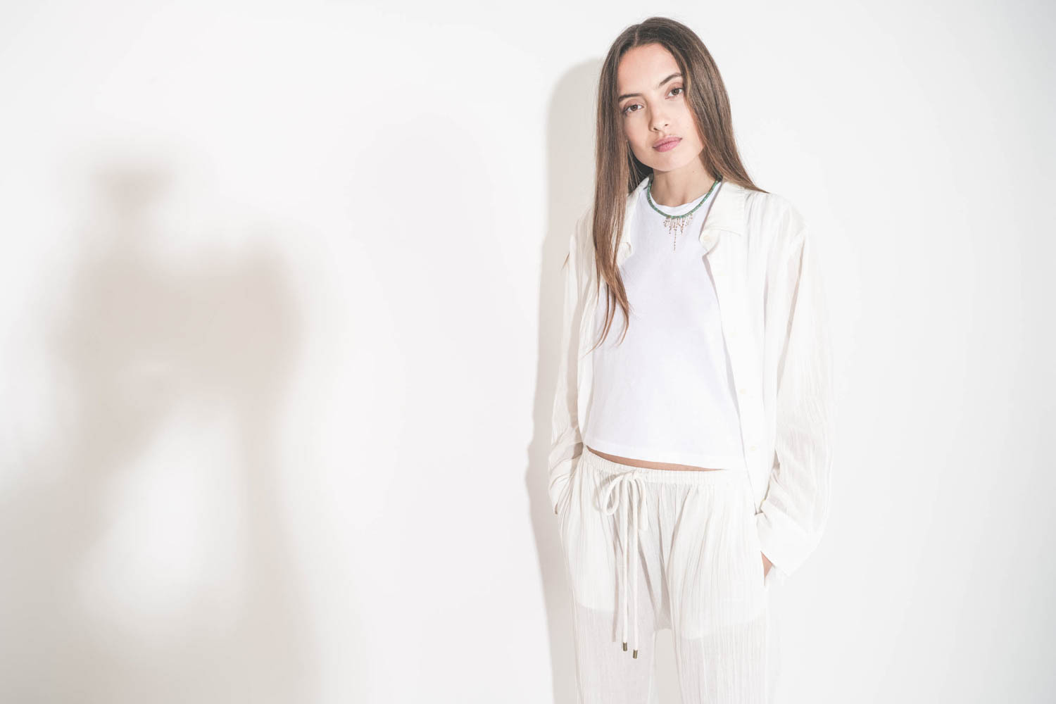 Collier ras du cou en turquoise et chaines en or jaune Taylor N°3 Pascale Monvoisin. Porté sur un tee-shirt blanc Peak Shoulder The Great et une chemise en voile de coton blanche Cove The Great et un pantalon sarouel Reef The Great.